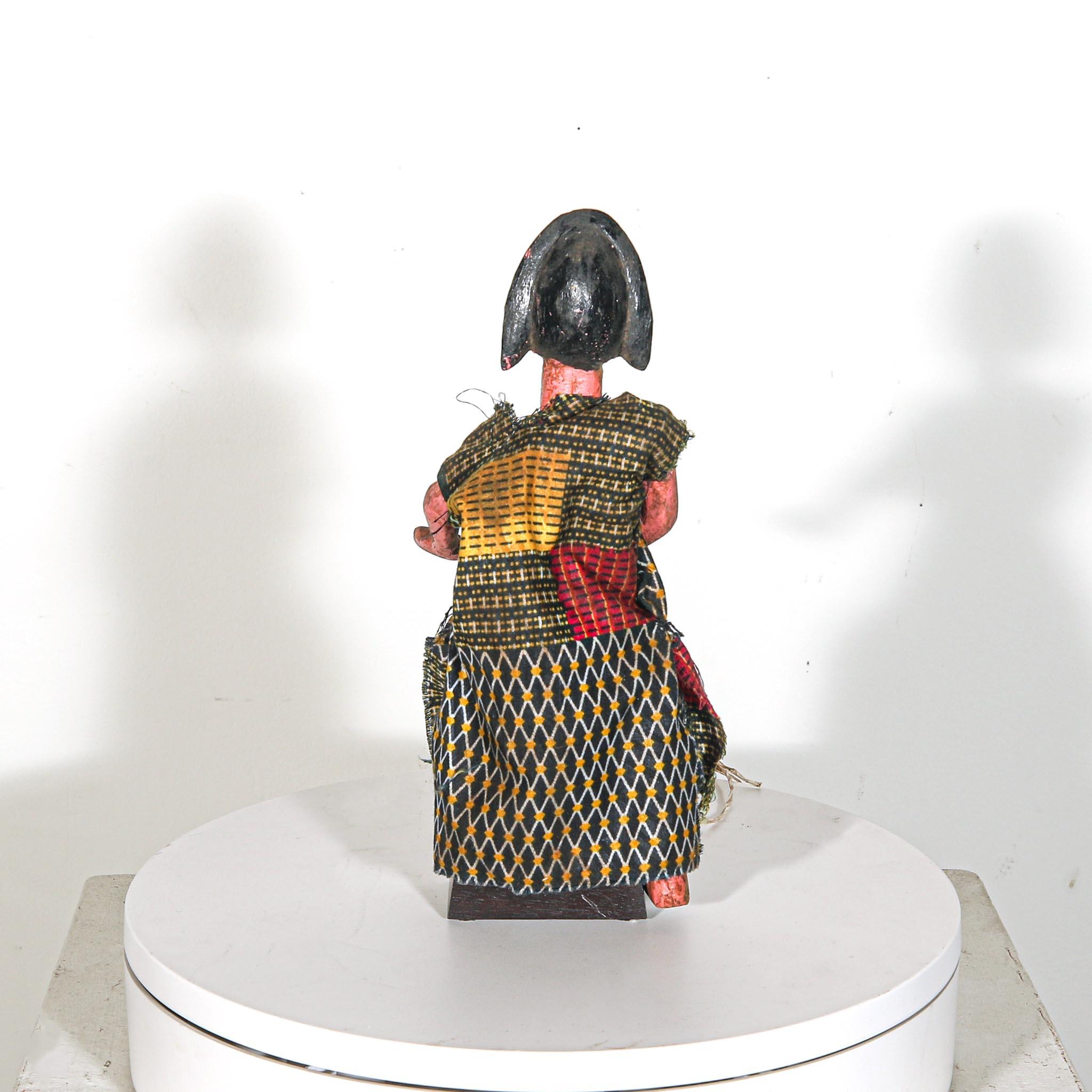 Puppet Doll from Mali standing on a display showing back