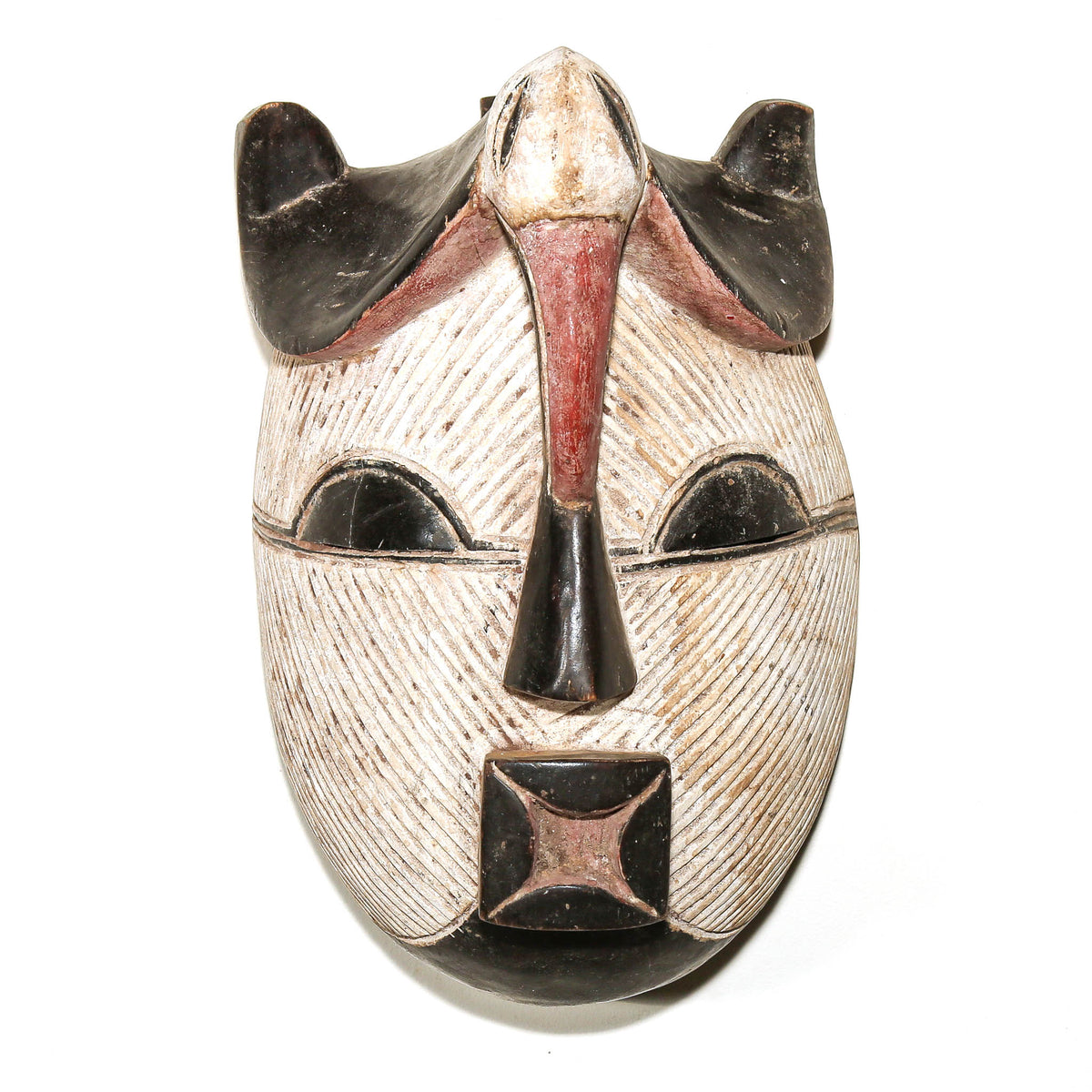 Black and white Songye mask from the Democratic Republic of Congo with bold carved geometric lines and traditional design