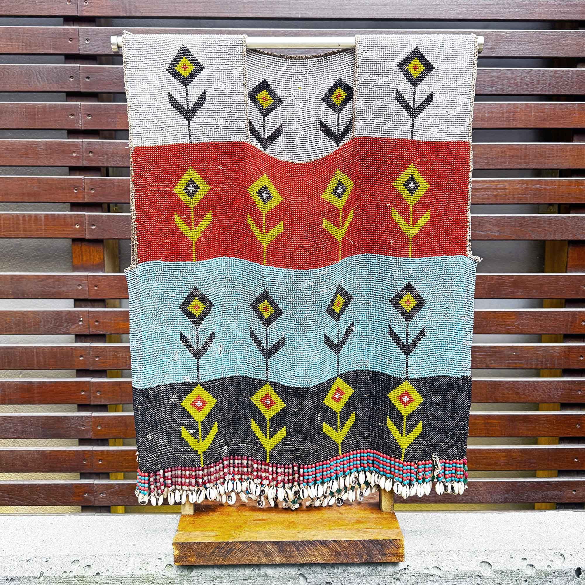vintage african art and fashion for sale with geometric pattern on a wooden stand against a wooden background