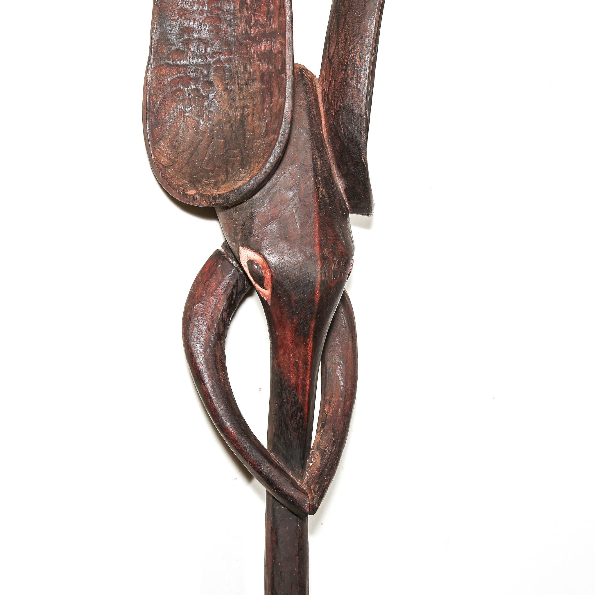 A close-up of a dark brown carved wooden wall hanging or decorative elephant sculpture with curved, organic shapes and visible wood grain, photographed against a plain white background.