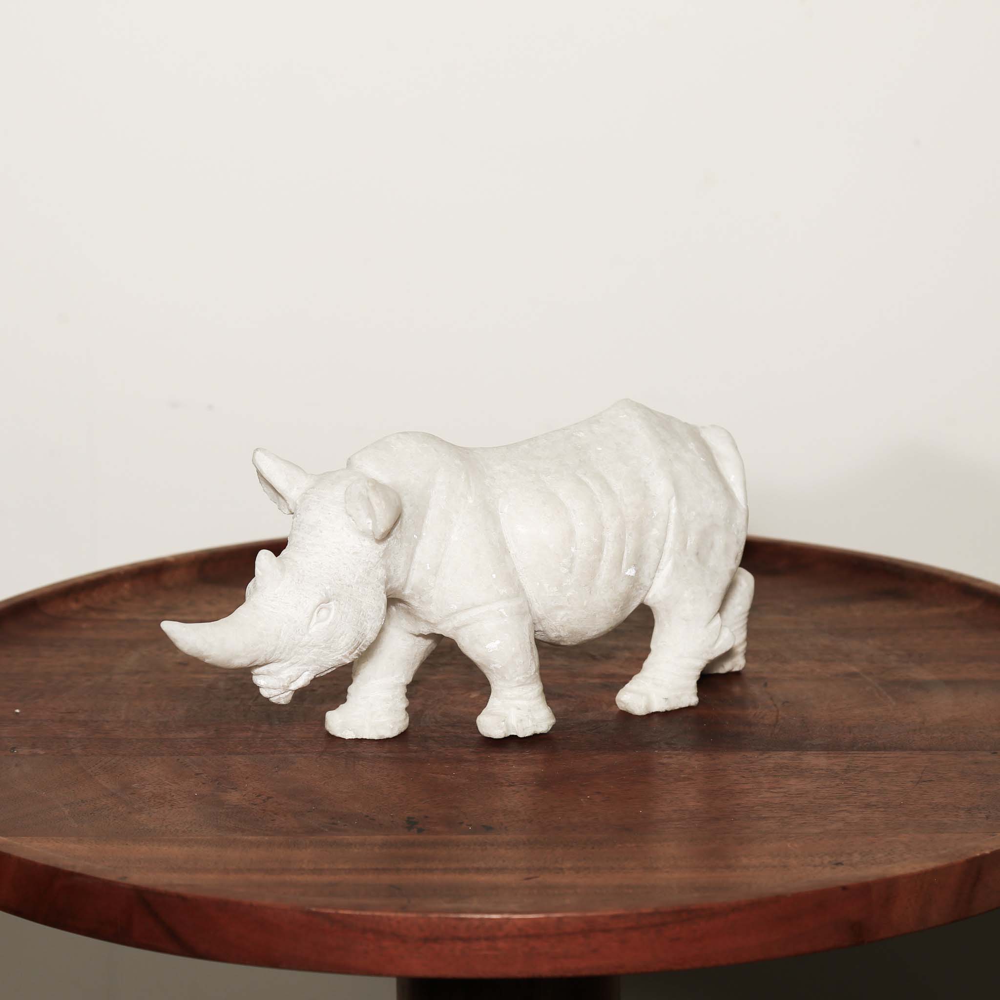 Black Rhinoceros Sculpture in White Stone as an animal figurine on a table 