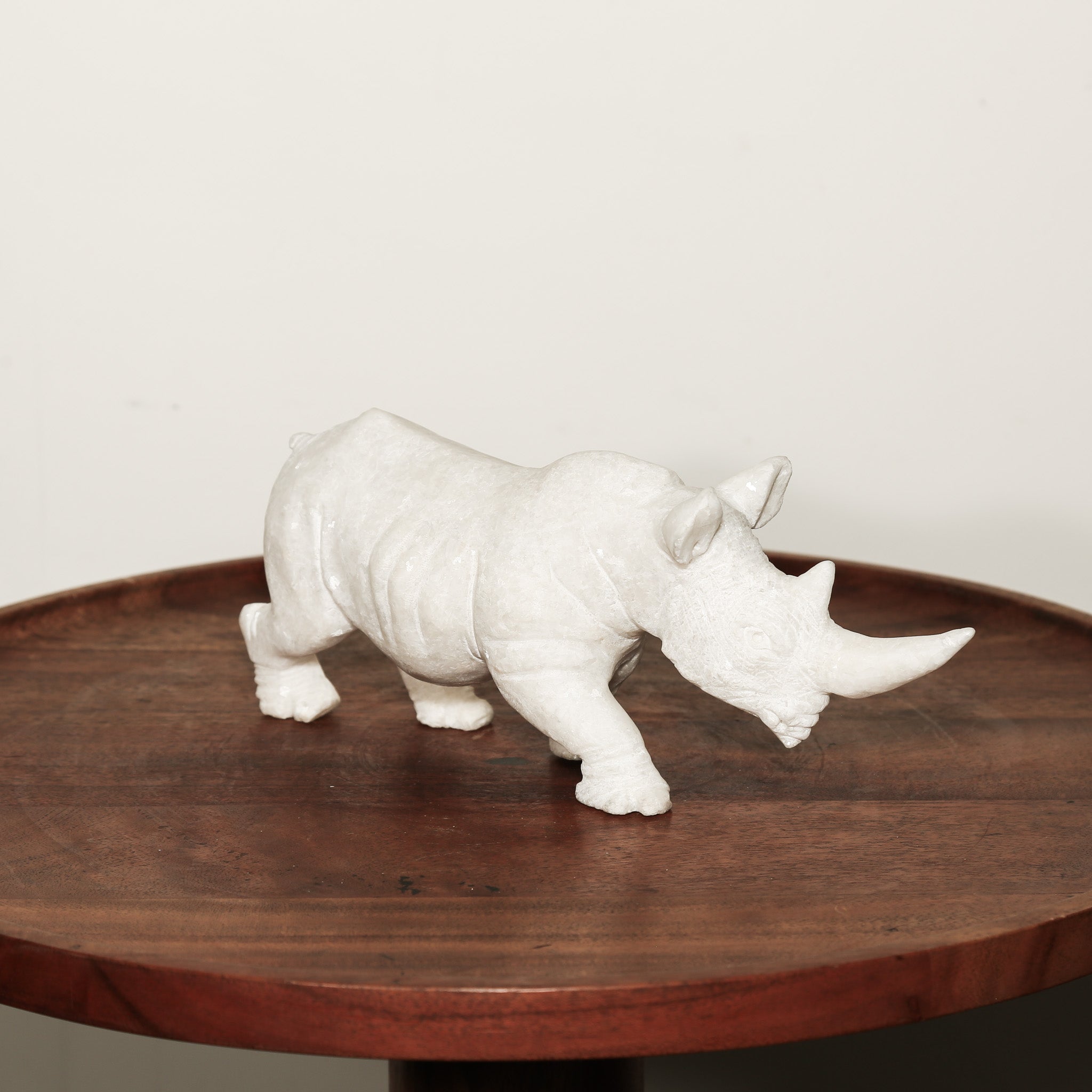 Black Rhinoceros Sculpture in White Stone presenting side 