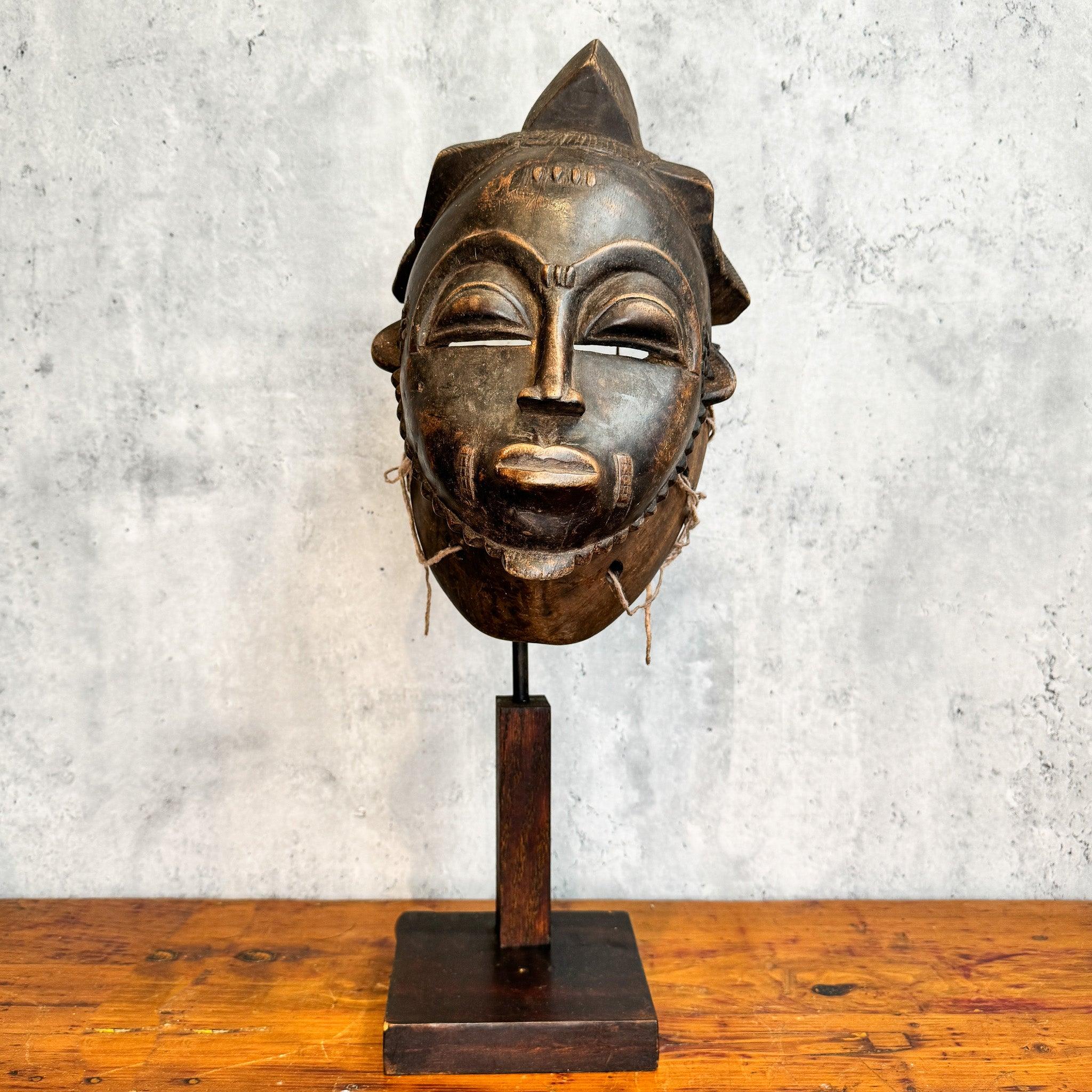 Front of Baule Kpan Mask from Cote d'Ivoire on a stand as an African mask decoration