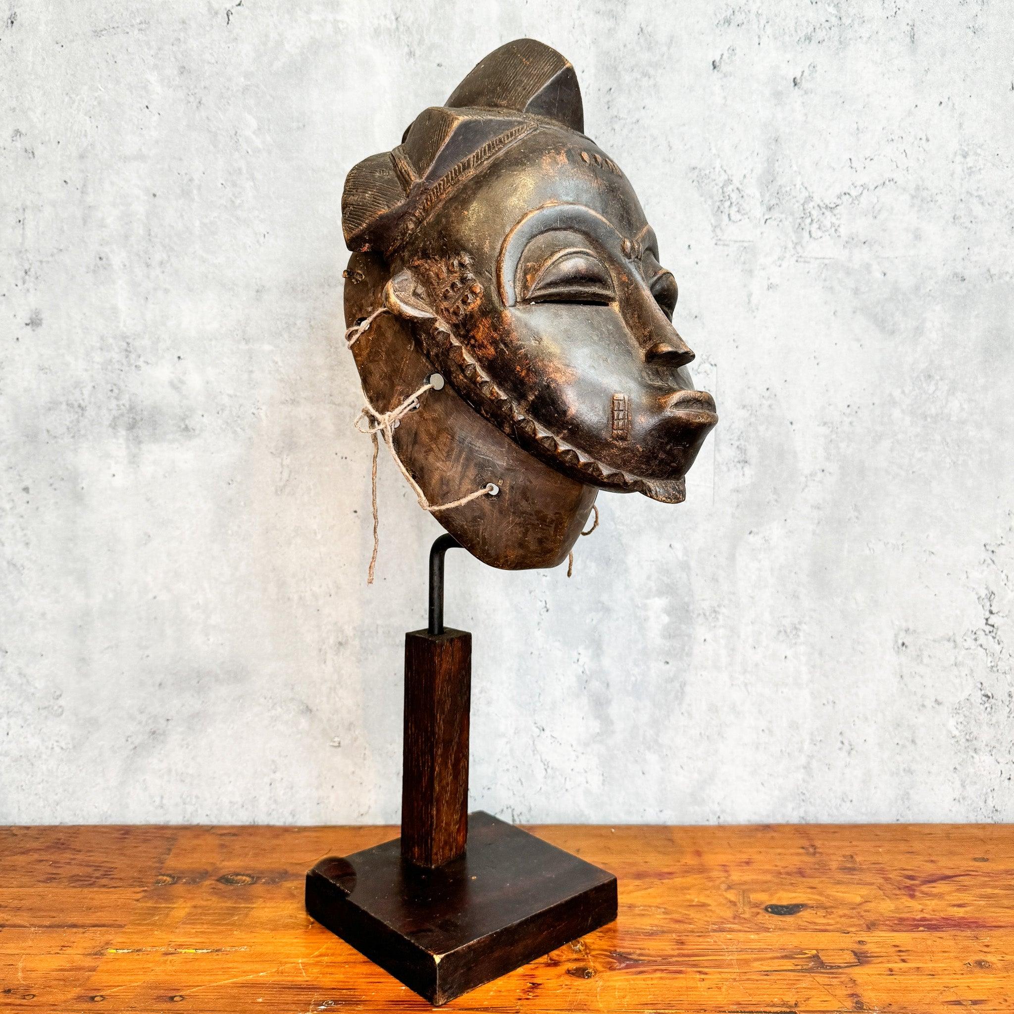 Baule Kpan Mask from Cote d'Ivoire on a stand as an African mask decoration at an angle 