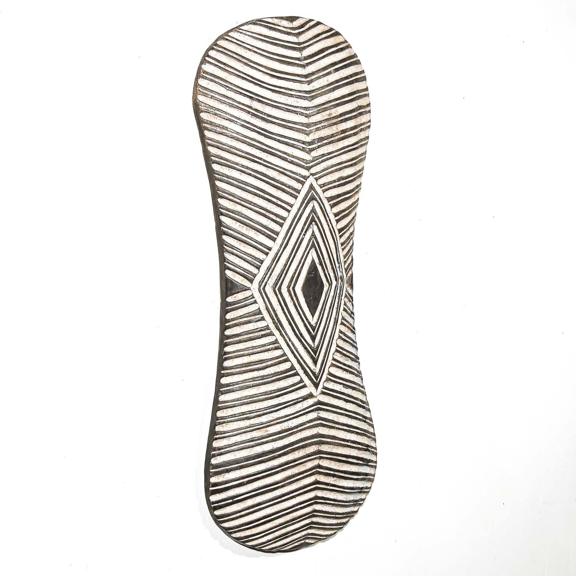 Decorative wall art from Africa with geometric pattern on a white home wall