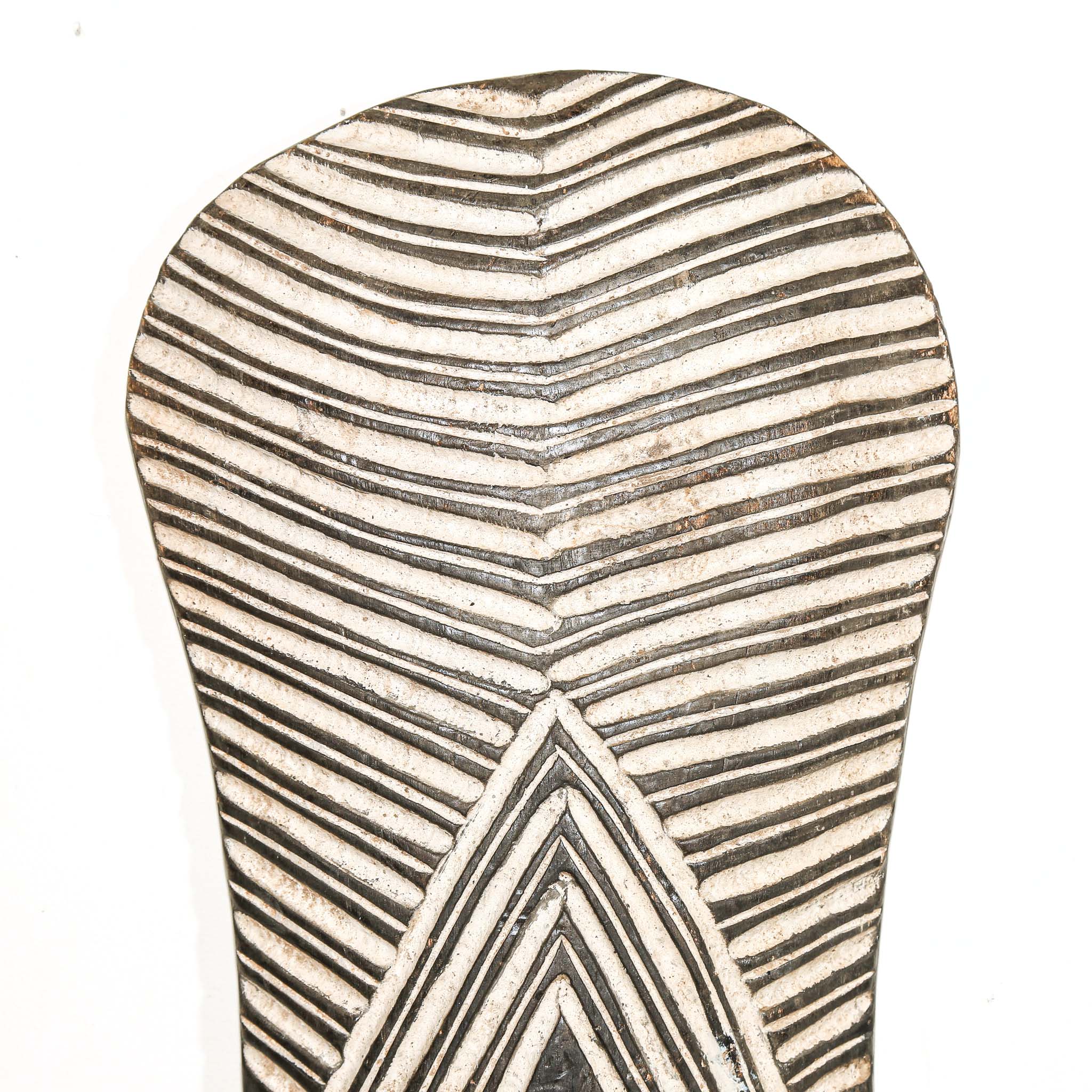 Decorative wall art from Africa with geometric pattern on a white home wall