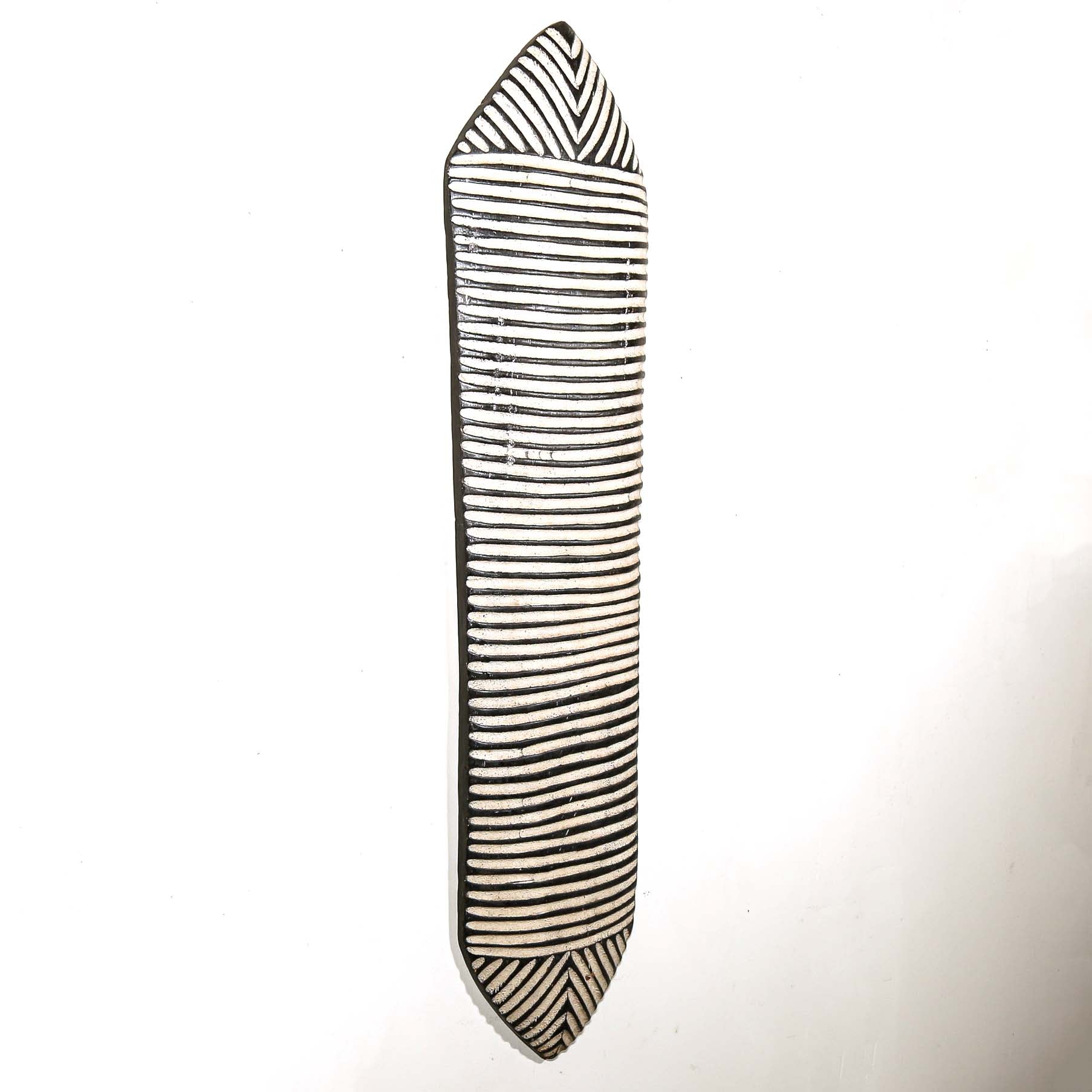 Black and white striped carved wood shield for wall design on a white background