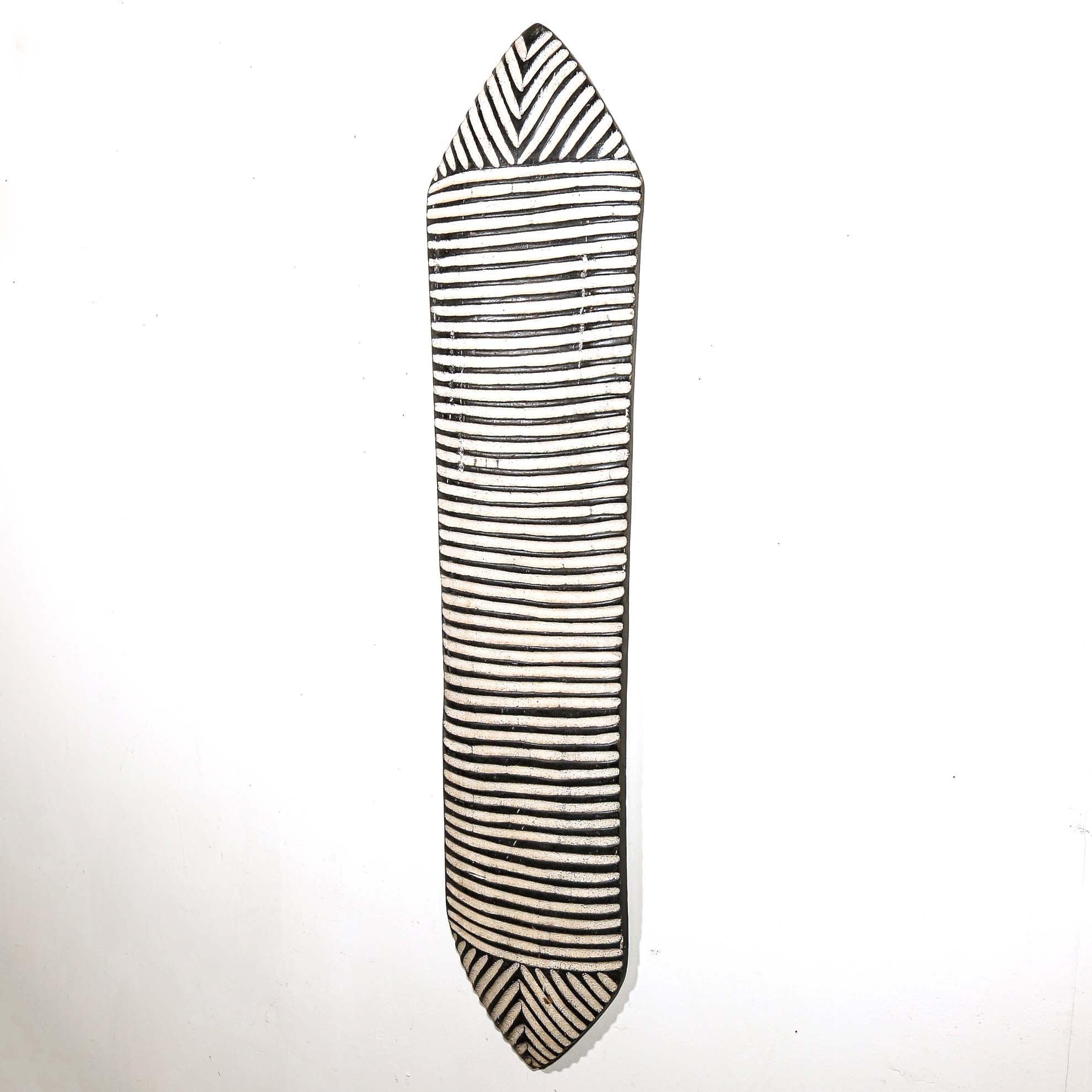 Black and white striped carved wood shield for wall design on a white background