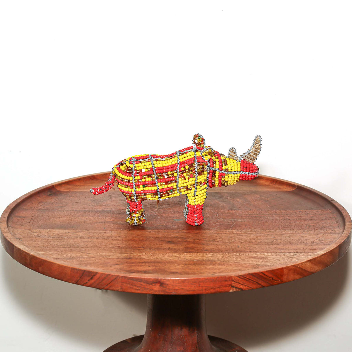 Tiny South African beaded wire rhino displayed as a handmade African animal sculpture for shelf or desk decor