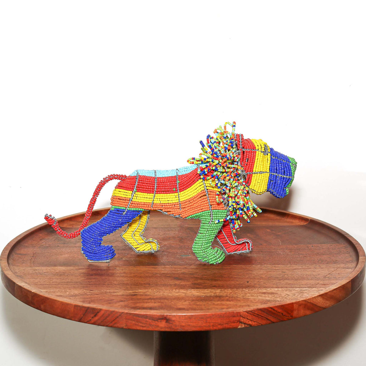 Colorful South African beaded wire lion displayed as a small handmade African animal sculpture for shelf or tabletop decor