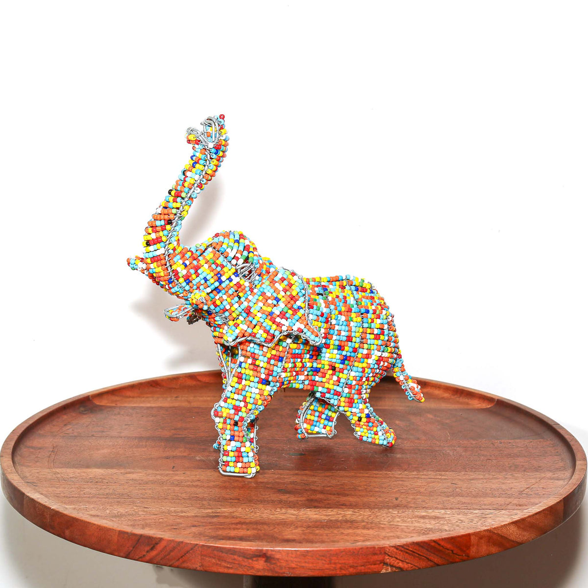 Small handmade elephant sculpture featuring multicolored beadwork, detailed wire construction, and African artisan craftsmanship
