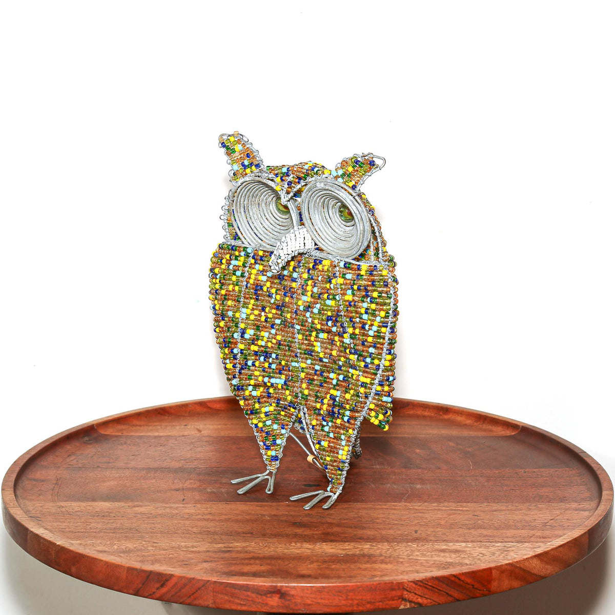 Decorative African owl made with colorful beads and golden details, designed as a small shelf or tabletop sculpture