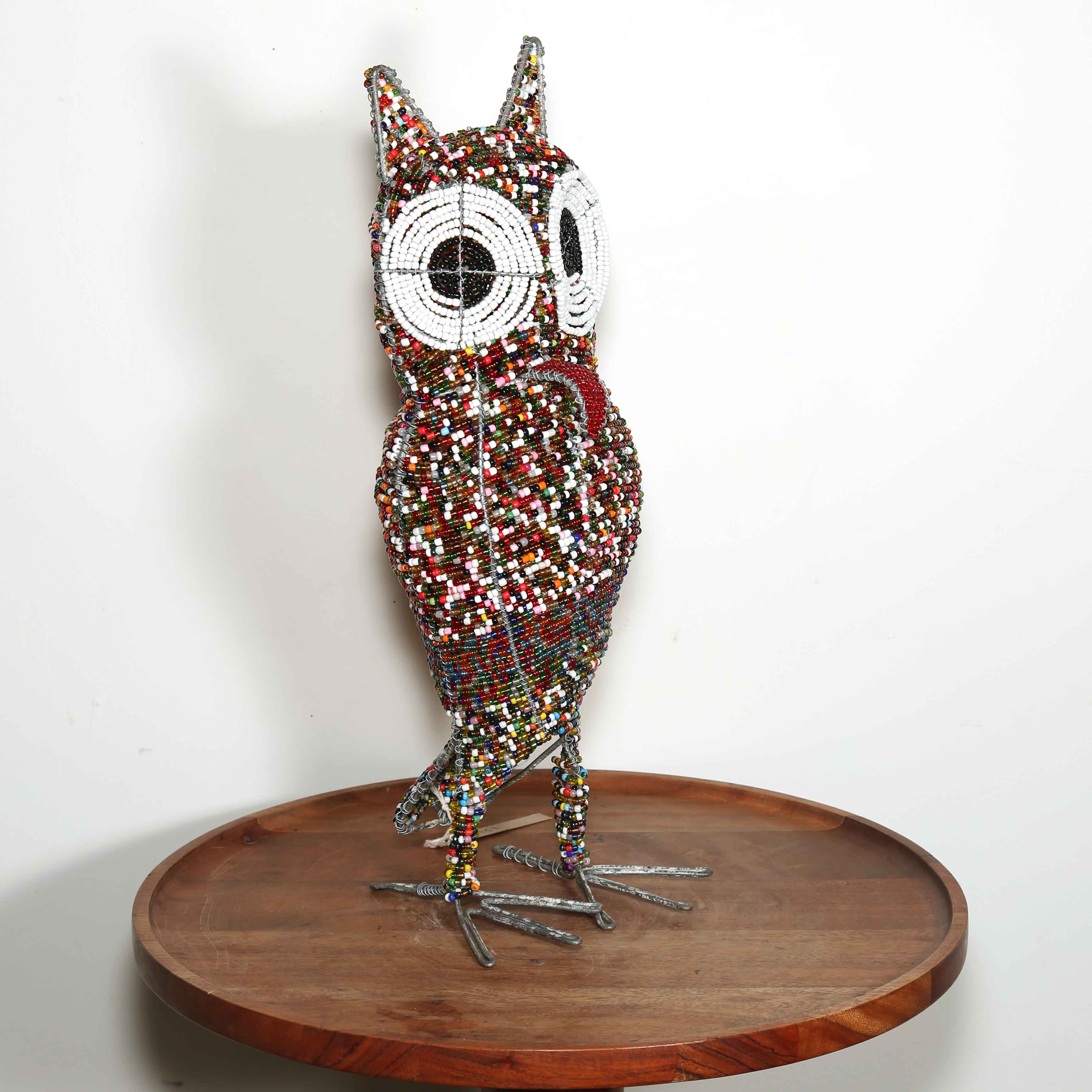 red pink and white African art of an owl made from beads