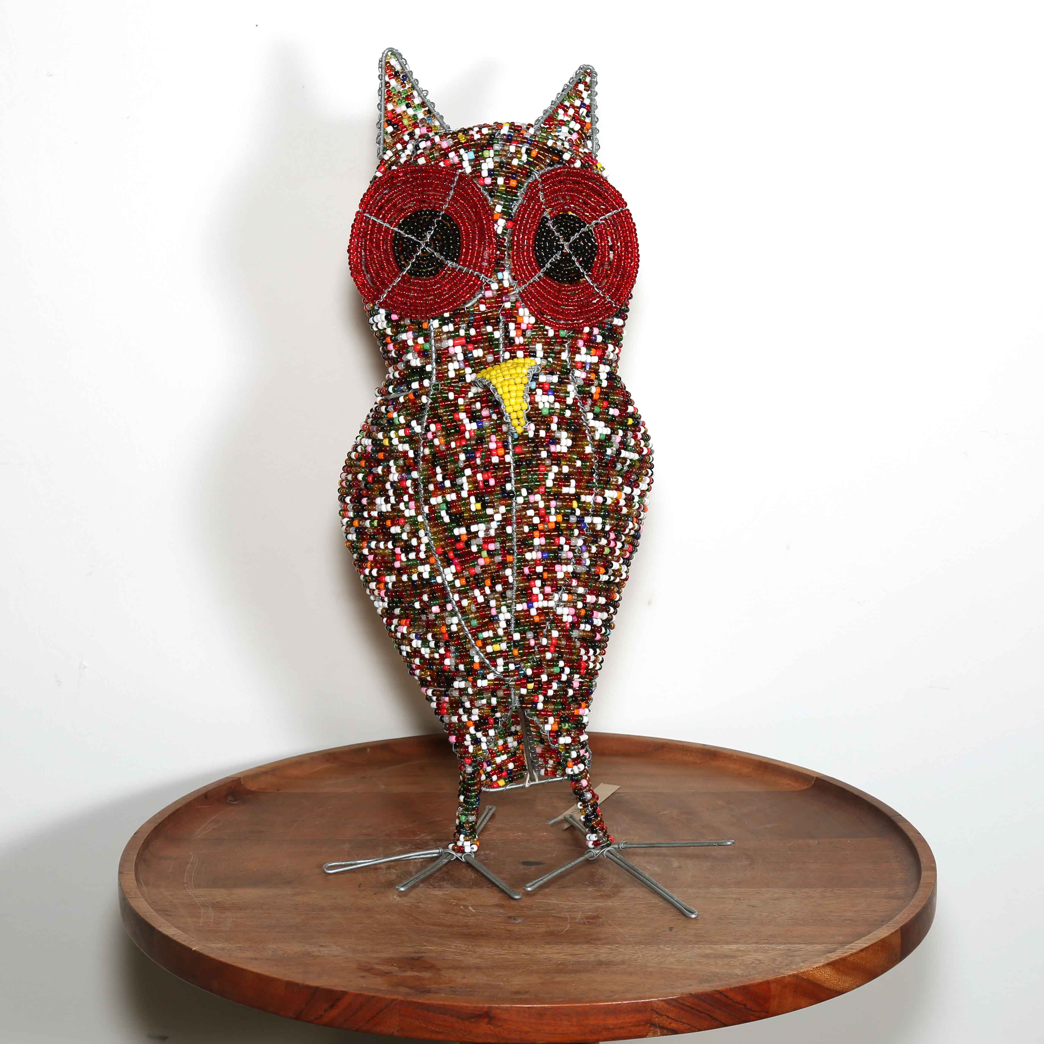 Beaded owl sculpture with red eyes and yellow beak made from beads