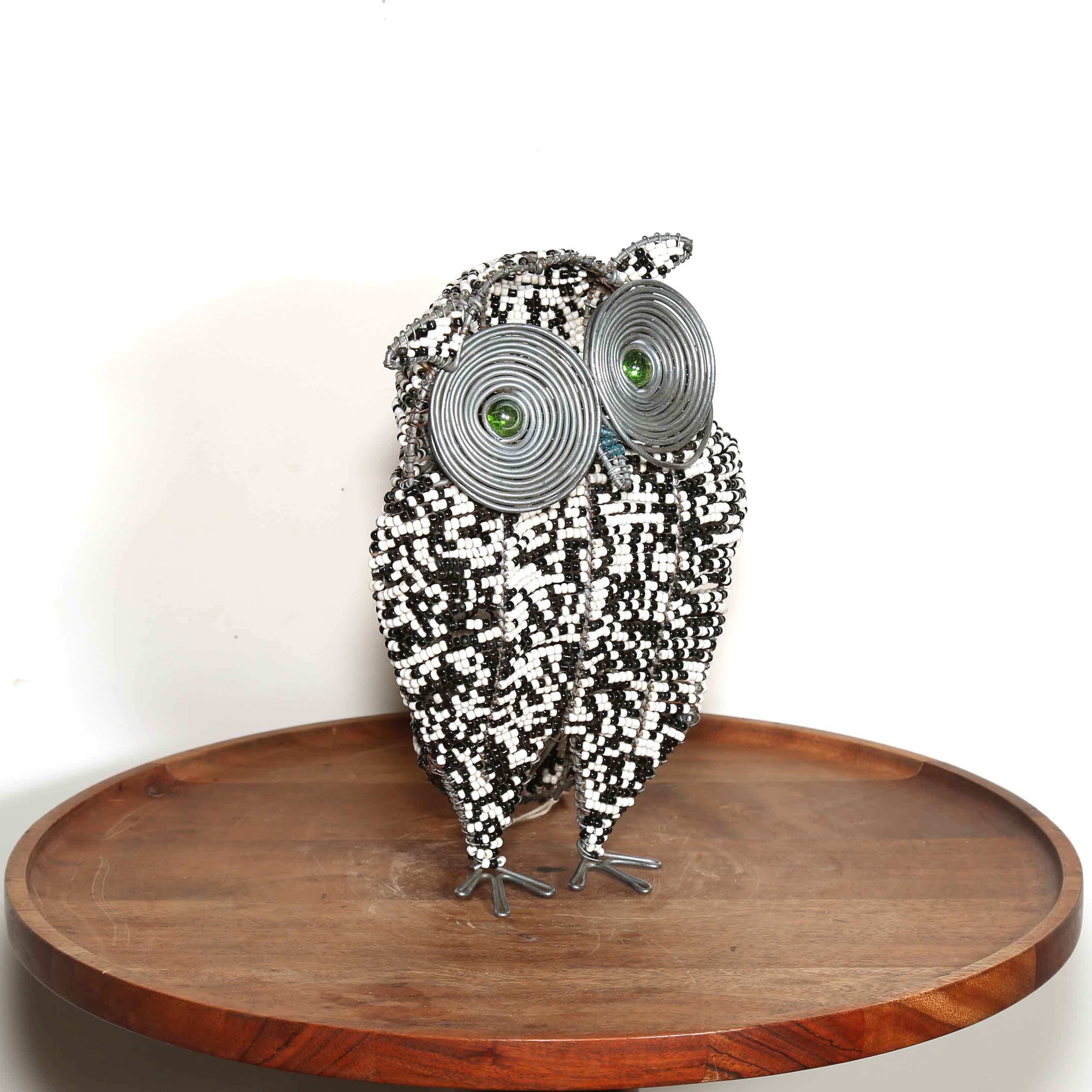 Metallic owl sculpture with black and white beads and green eyes 