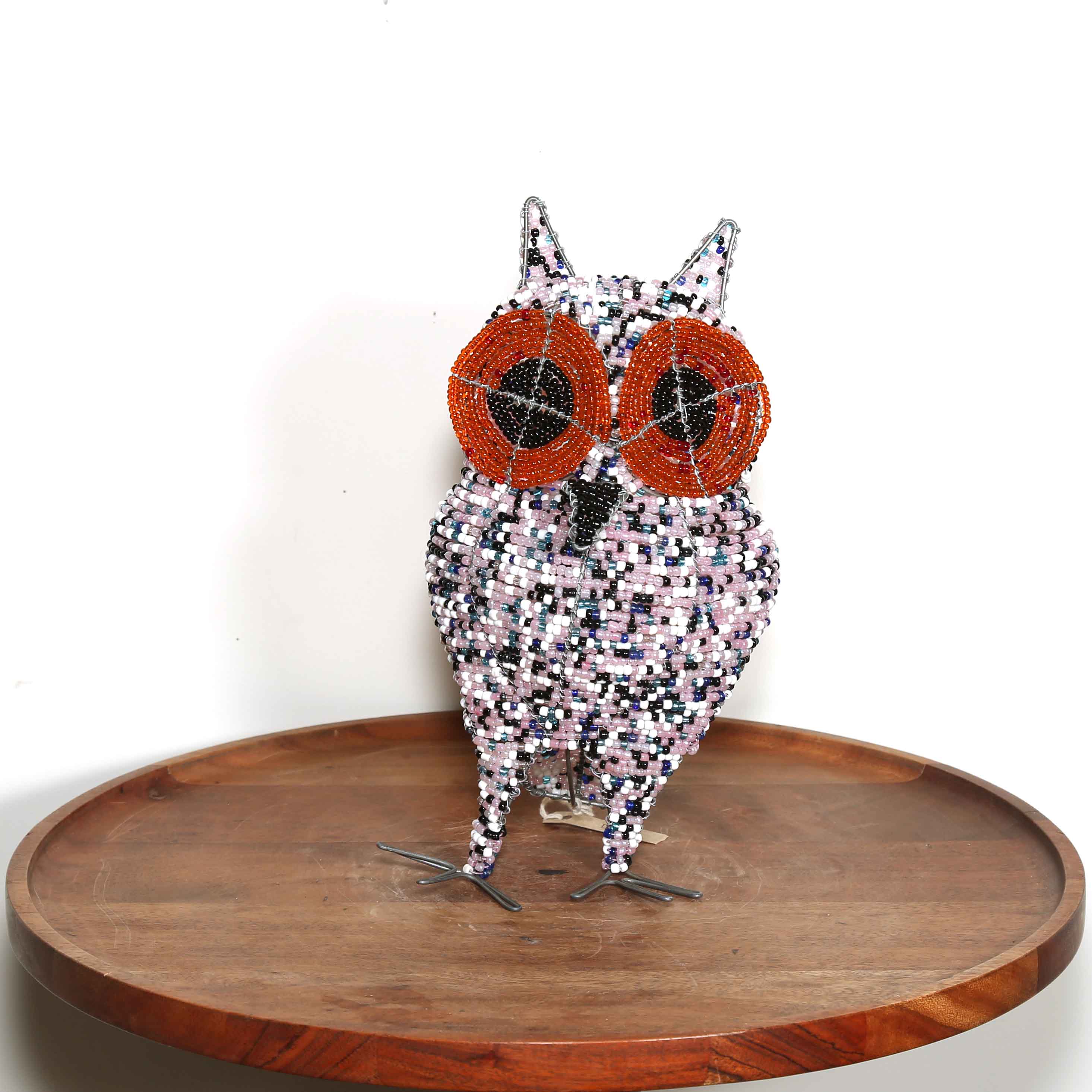 speckled pink African owl artwork with black and orange eyes