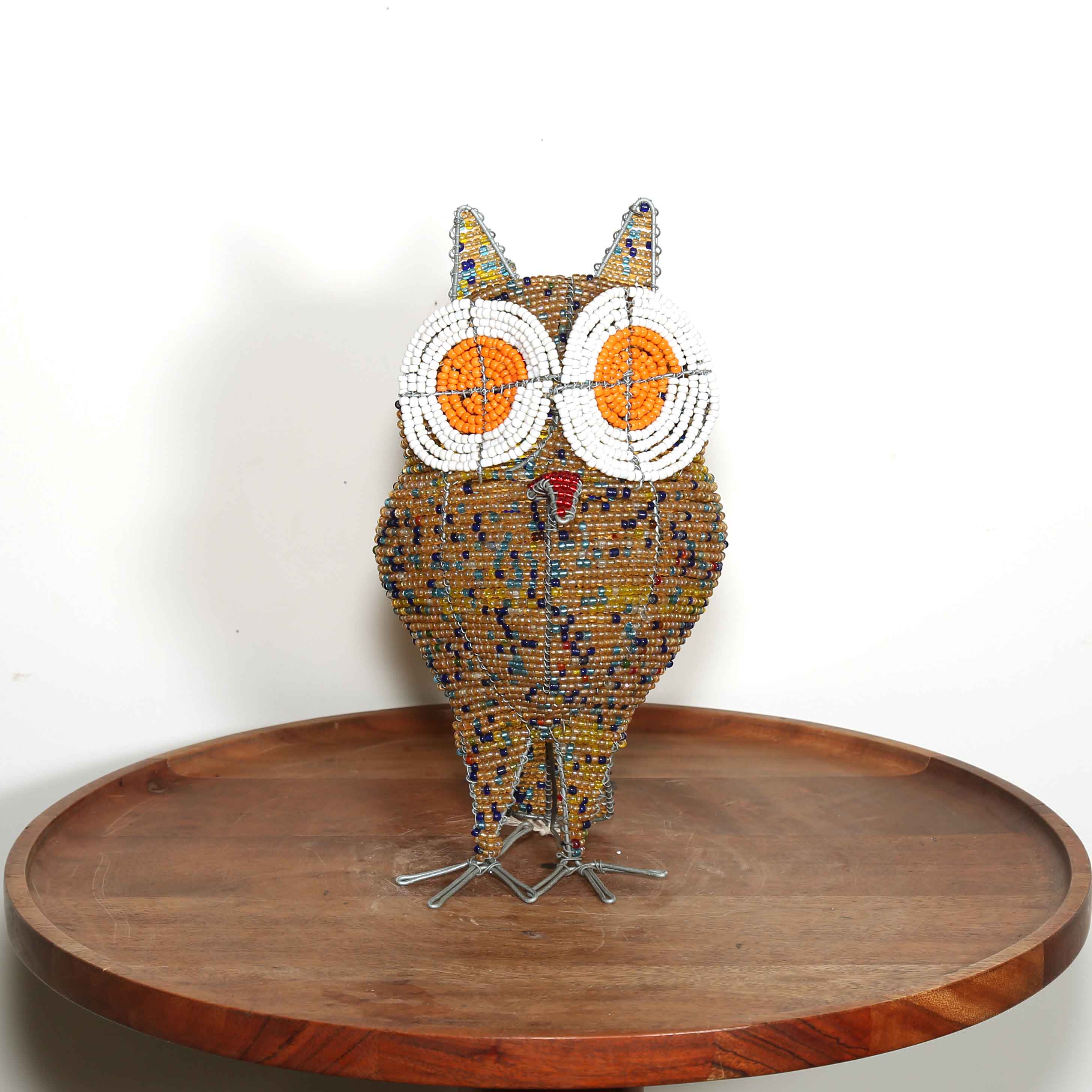 speckled gold African owl artwork with white and orange eyes