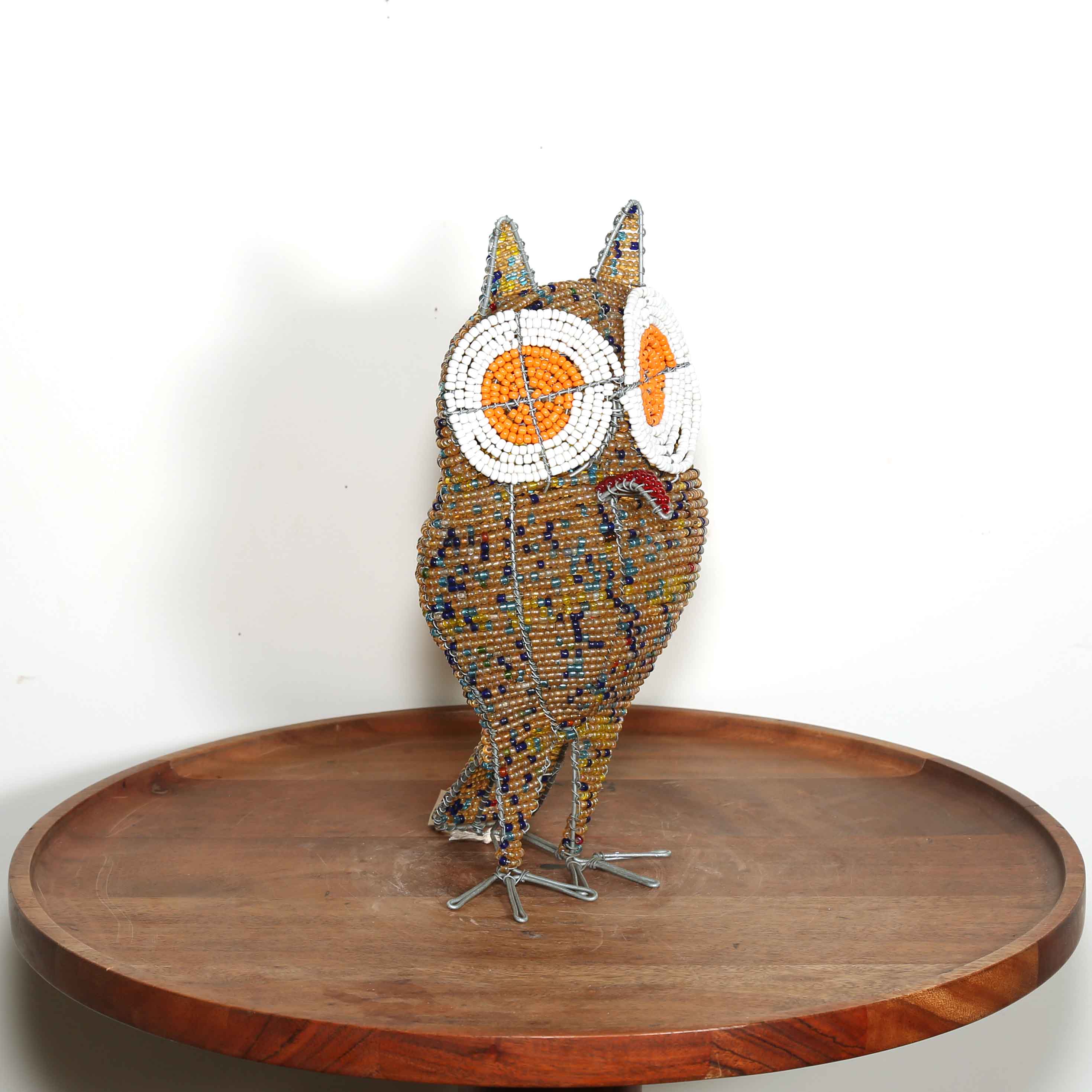 speckled gold African owl artwork with white and orange eyes handmade in Africa