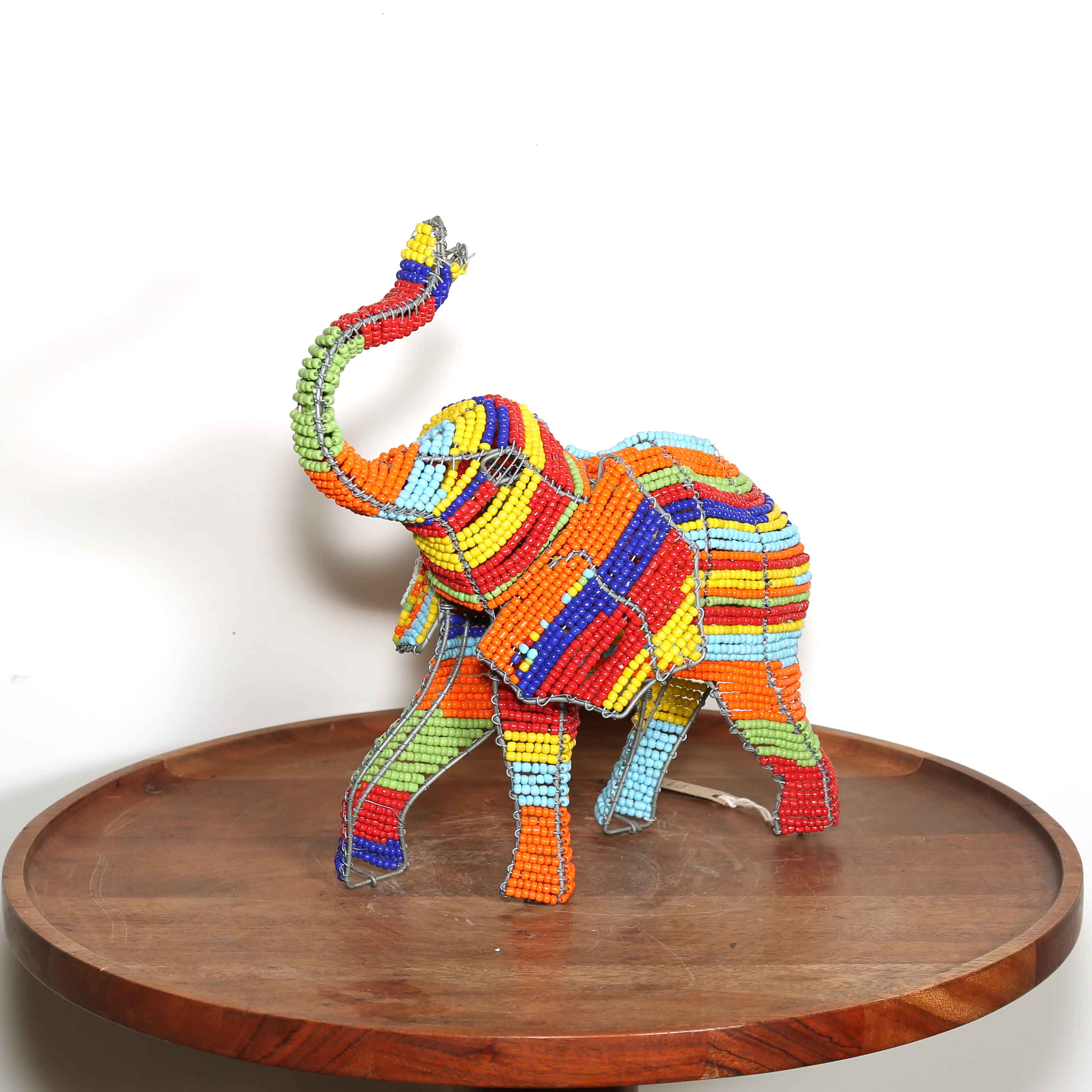 sculpture of an elephant with its trunk in the air made from wire and colorful beads
