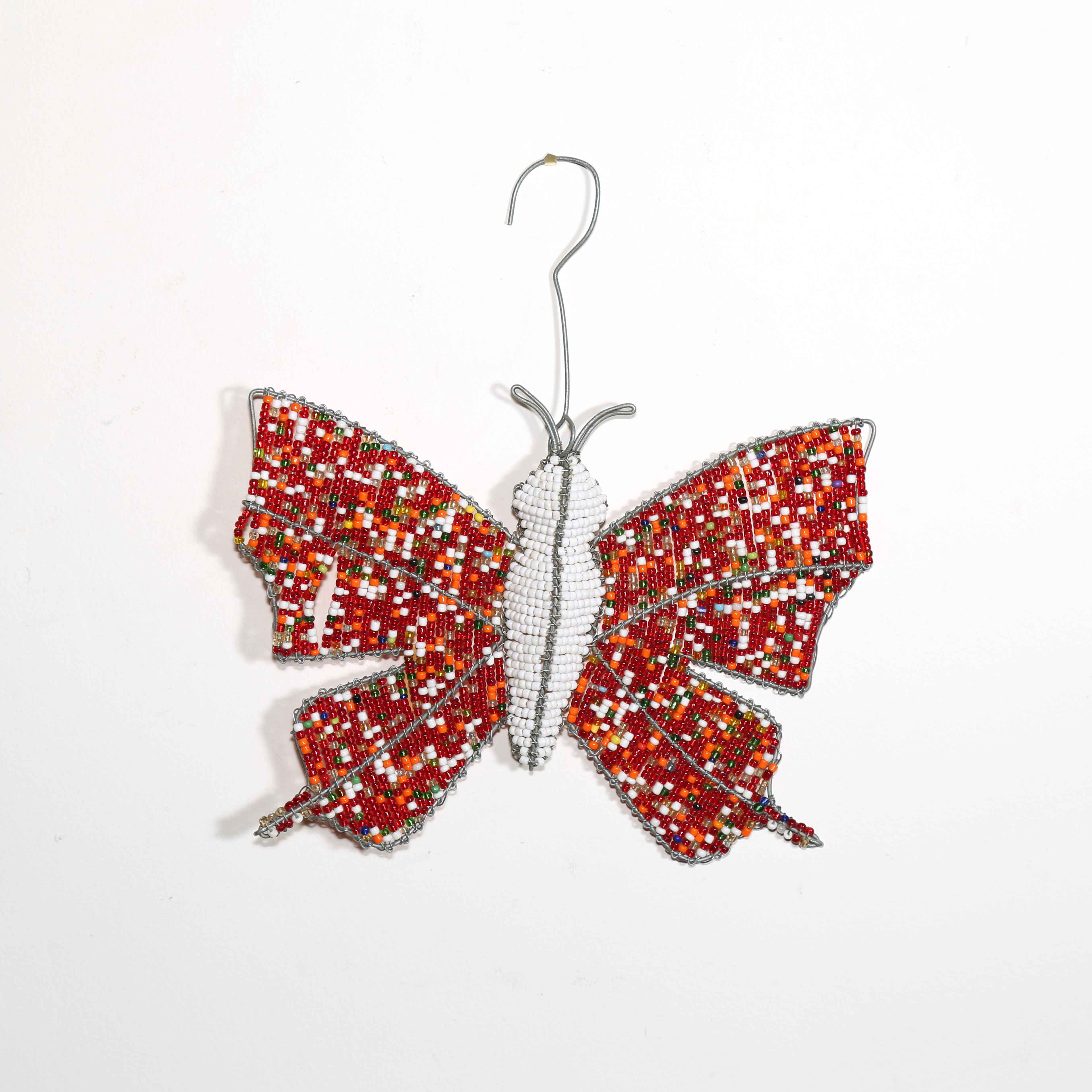 Decorative butterfly ornament with red and orange pattern on a white background