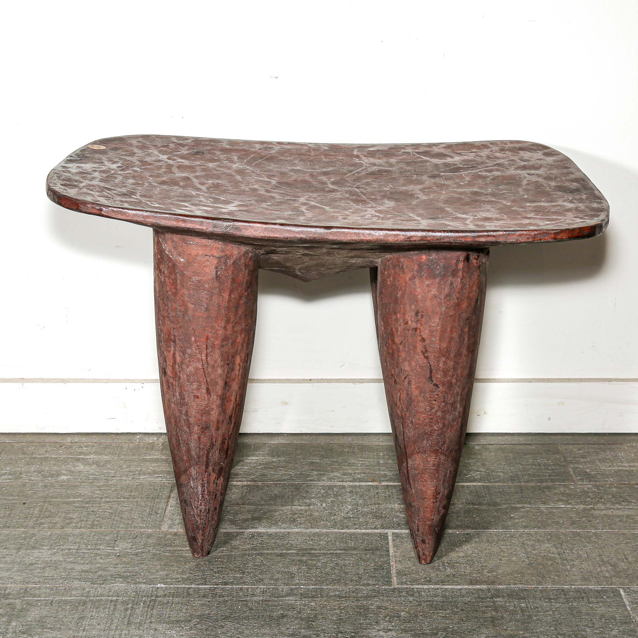 square African wood table with four pointed legs on a wooden floor
