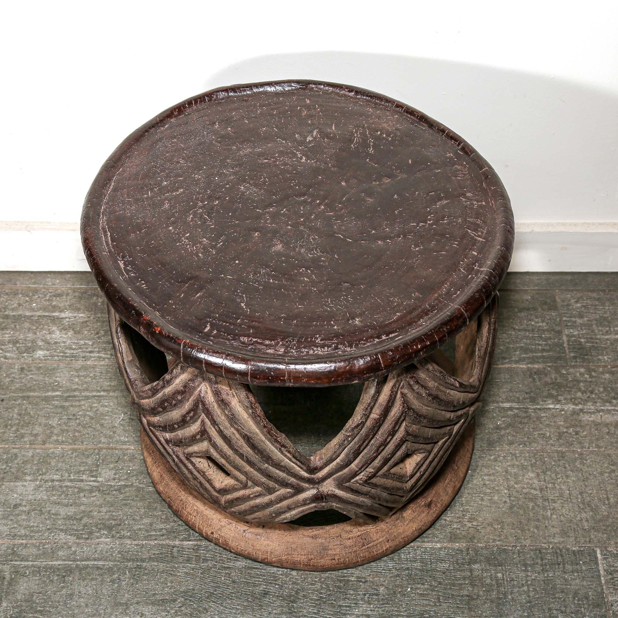 African style decor round table with geometric hand made pattern on a living room floor.