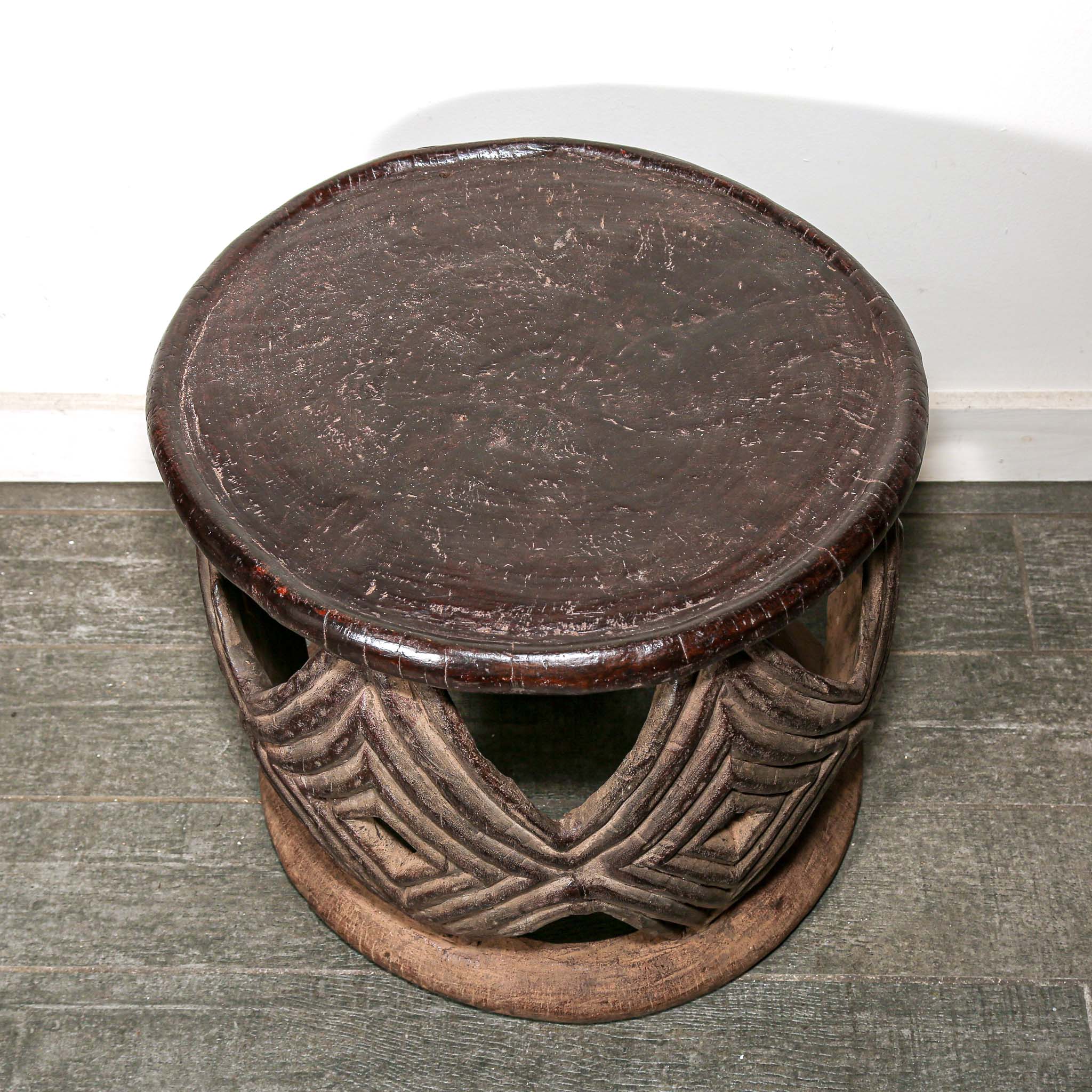 African style decor round table with geometric hand made pattern on a living room floor.