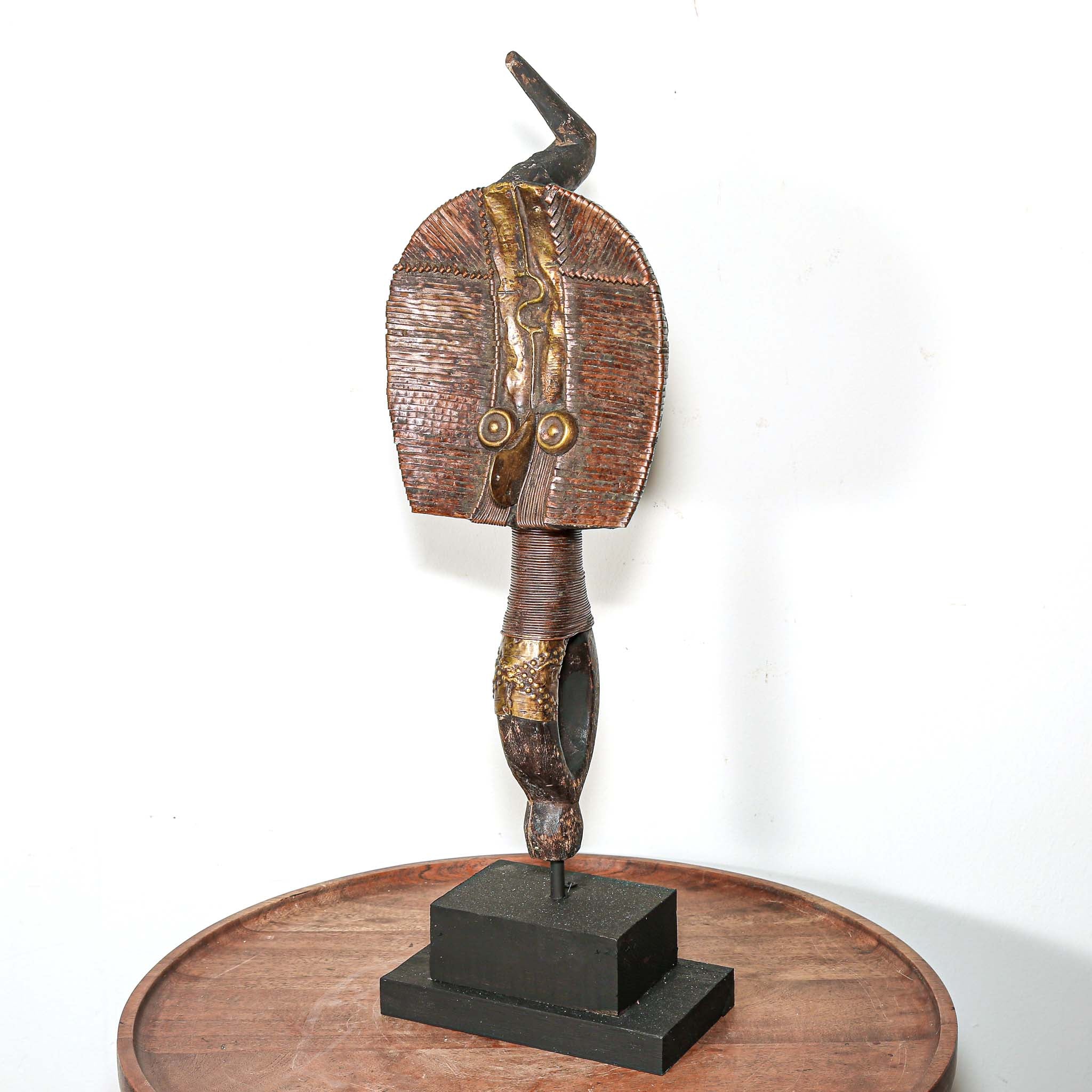 Decorative vintage African art on a stand with a white background