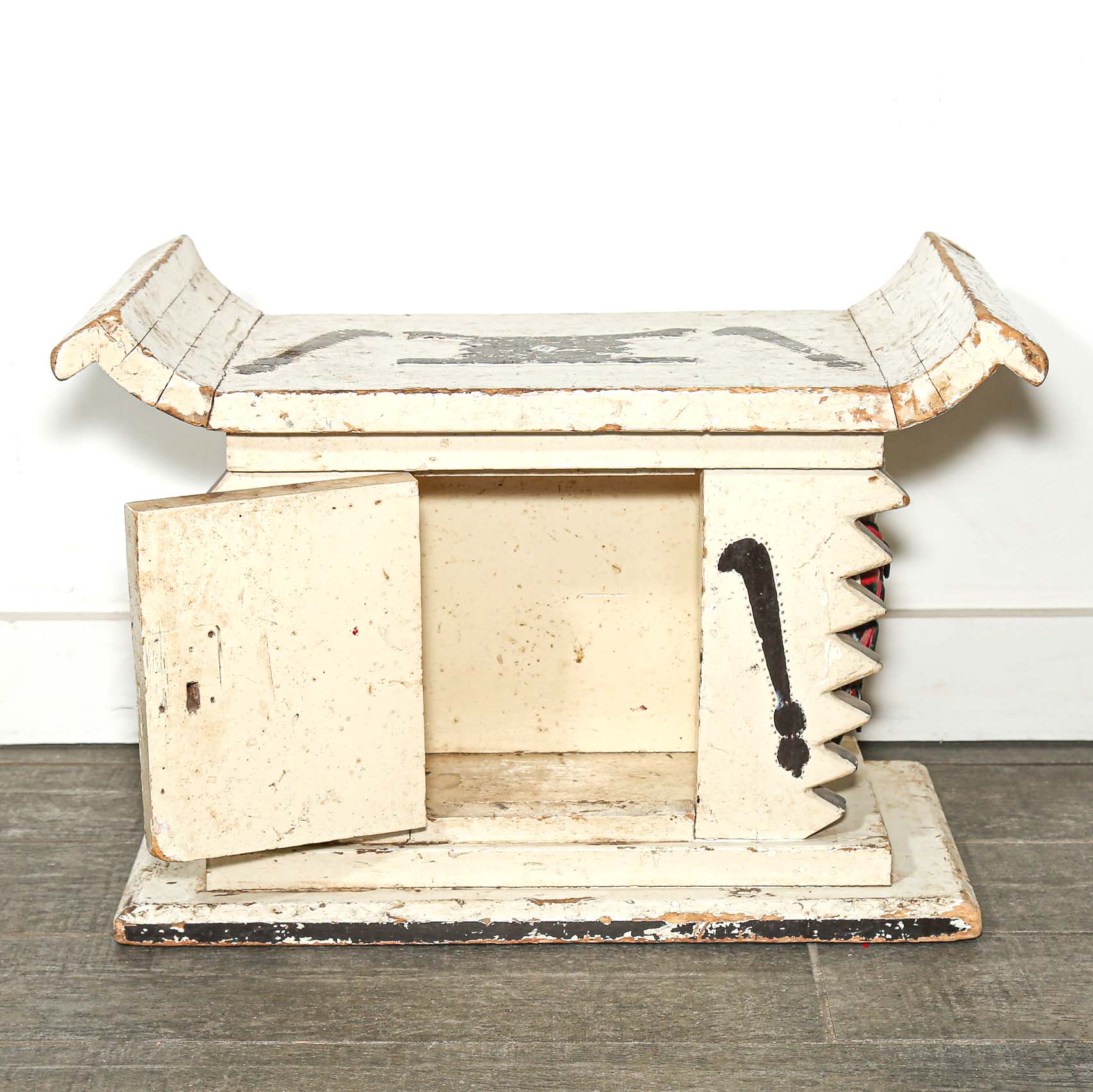 White wooden African stool furniture with cabinet and black accents on a wooden living room floor