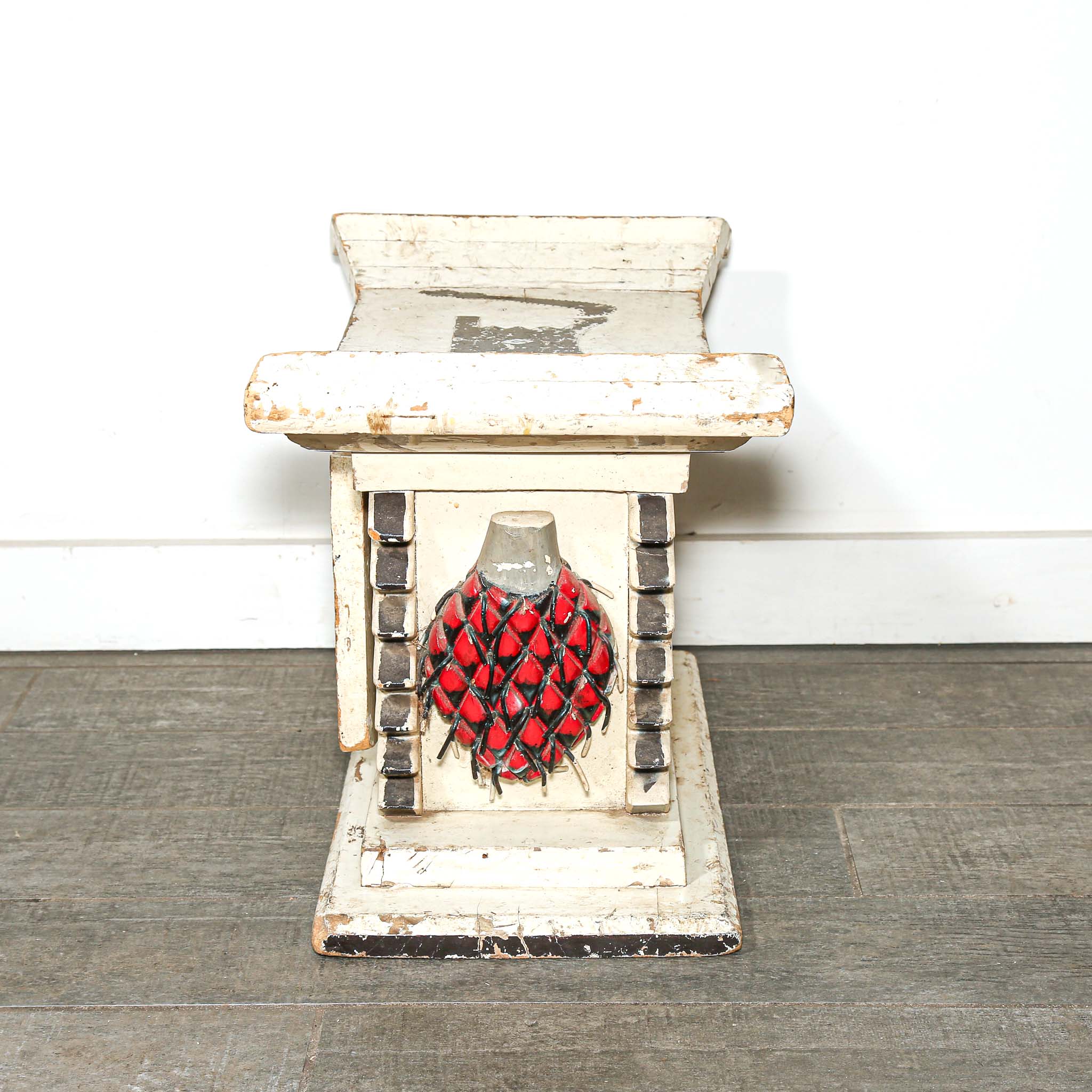 White wooden African stool furniture with cabinet and black distressed accents on a wooden living room floor