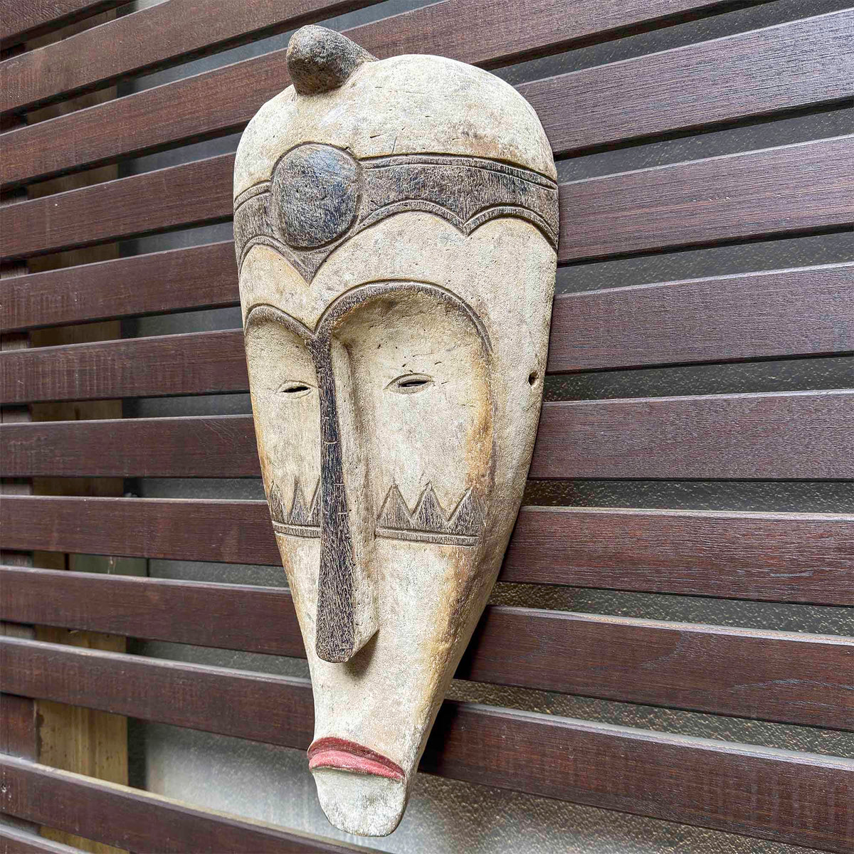 Oversized Fang face mask featuring a long narrow form, refined carved details, and traditional Gabonese styling