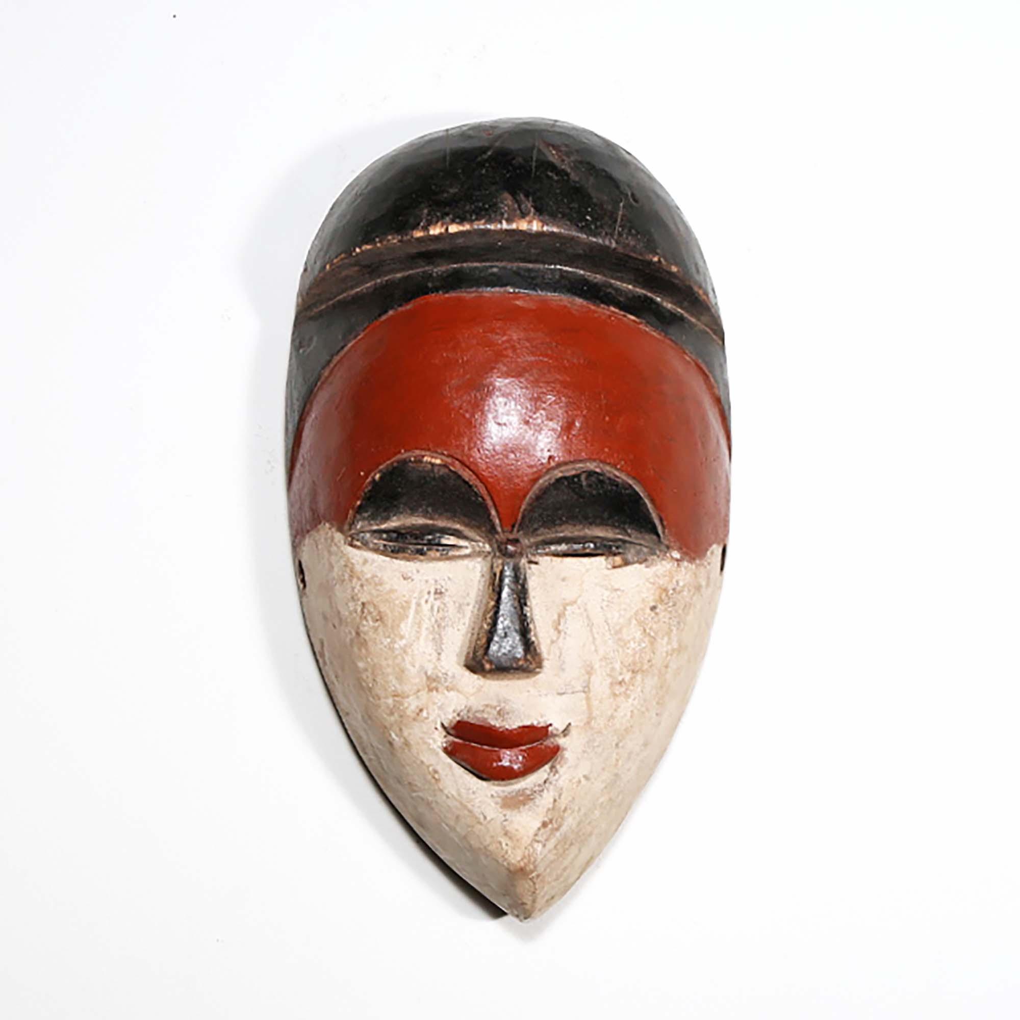 Igbo Style African Mask from Nigeria in red as a wall decoration in front