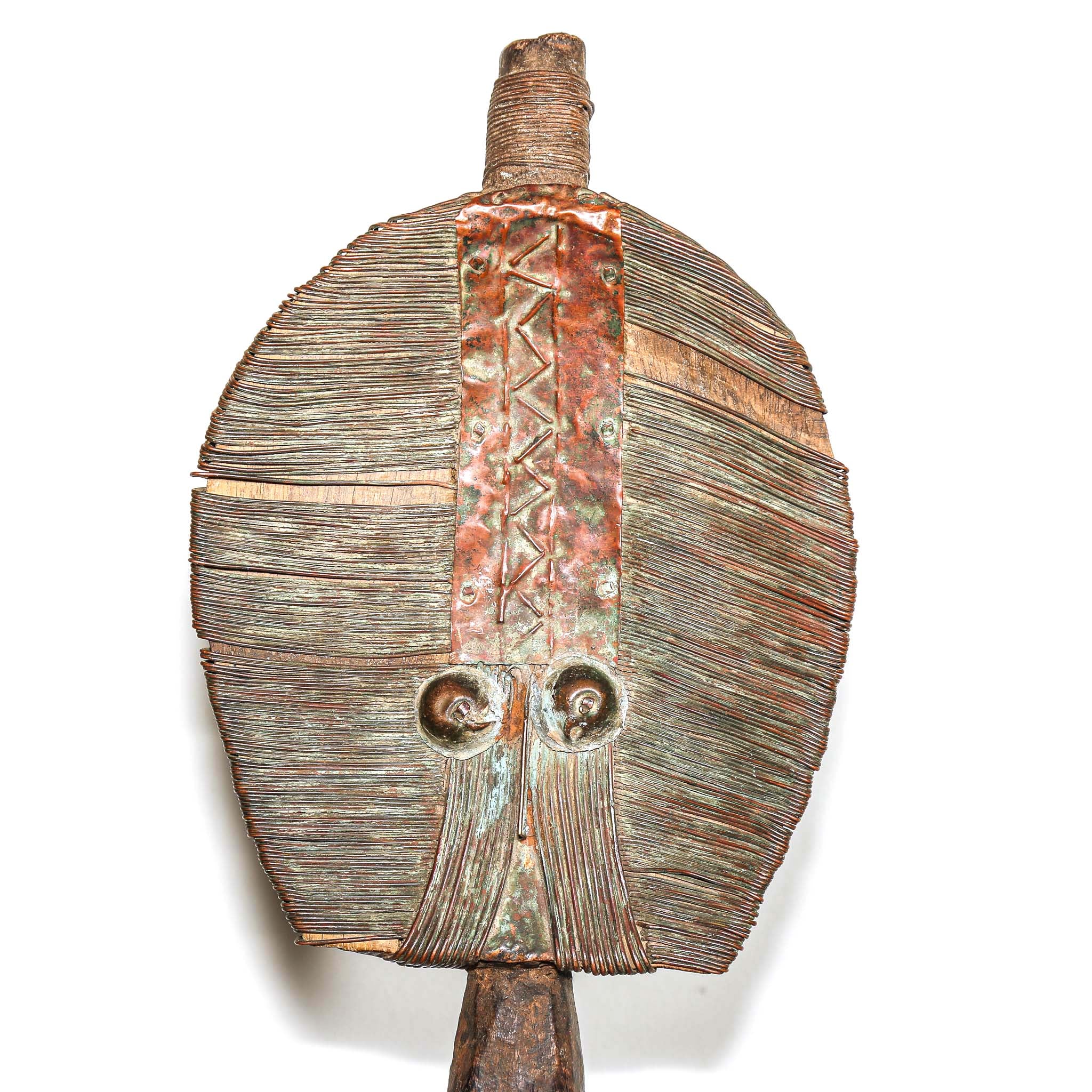 Wooden protective traditional mask from Gabon made from wood and metal on a round wooden table with a white background