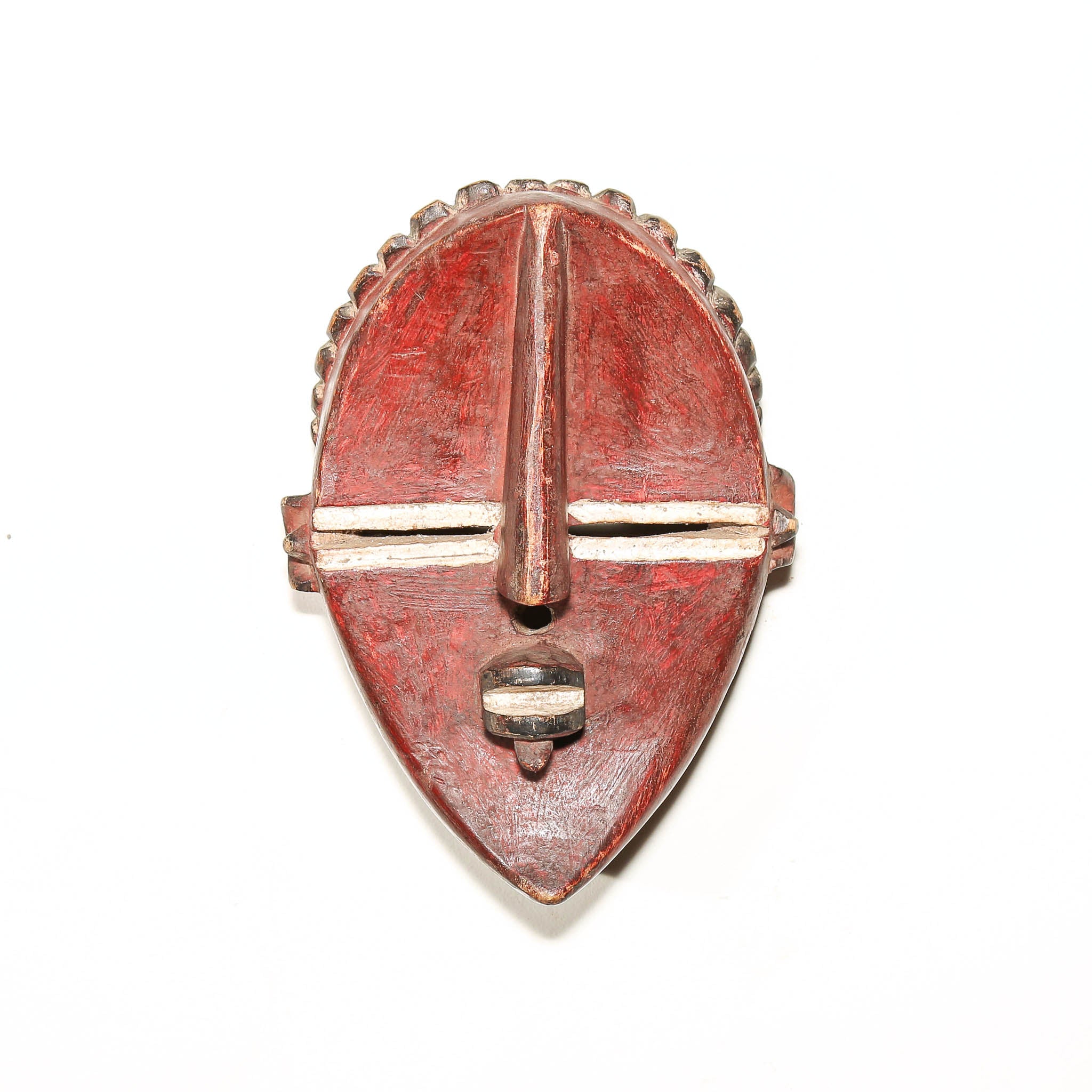 A carved wooden African-style mask with a reddish-brown painted finish and light natural wood accents, photographed against a plain white background.