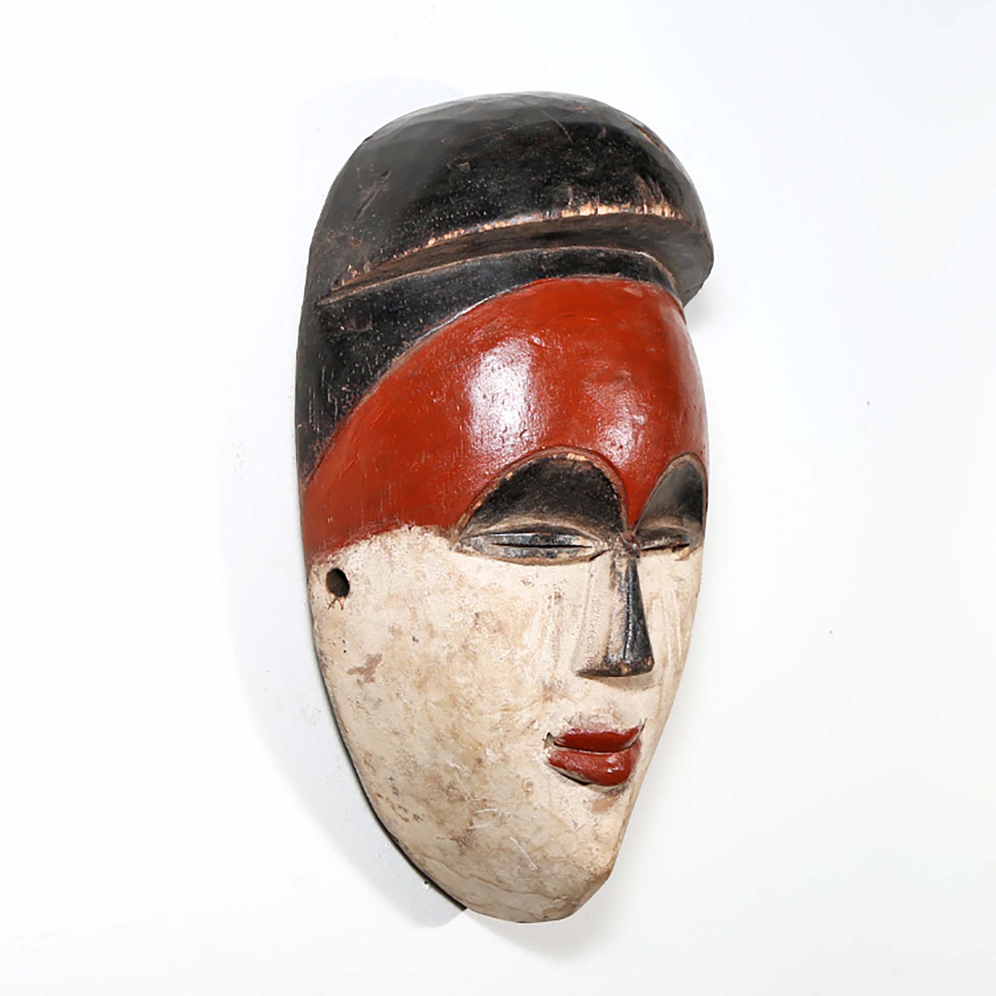 In the cultures of the Luba and Songye, a mask is known as a kifwebe, a term designated for African masks embodying spirits and distinguished by grooved patterns. Kifwebe masks, traditionally performed in rites of passage, were invoked by community heads to maintain harmony and used as a safeguard against malevolent spirits. This mask, while reflecting the essence of those historical pieces, is a modern decorative art piece.