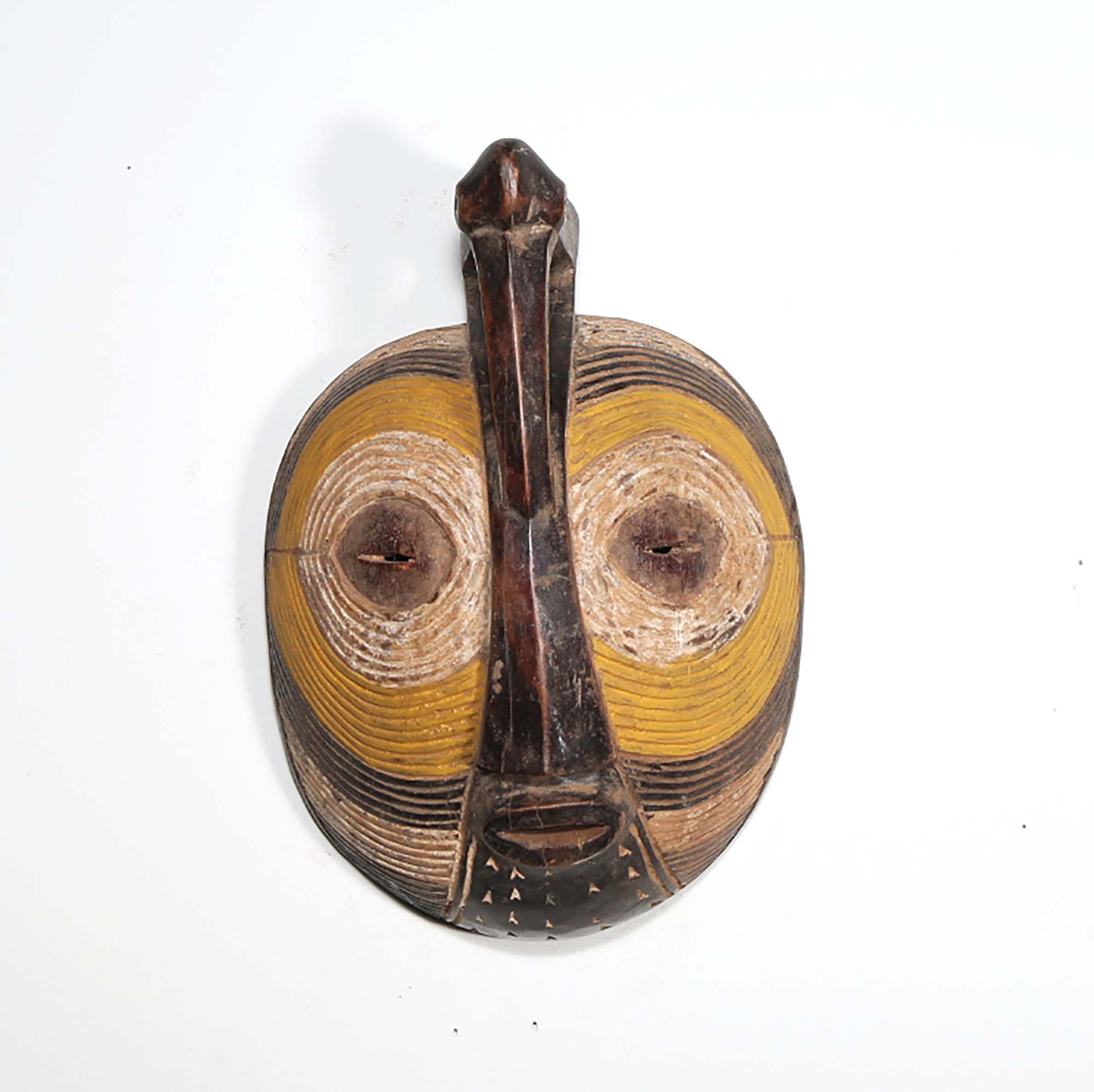 In the cultures of the Luba and Songye, a mask is known as a kifwebe, a term designated for African masks embodying spirits and distinguished by grooved patterns. Kifwebe masks, traditionally performed in rites of passage, were invoked by community heads to maintain harmony and used as a safeguard against malevolent spirits. This mask, while reflecting the essence of those historical pieces, is a modern decorative art piece.