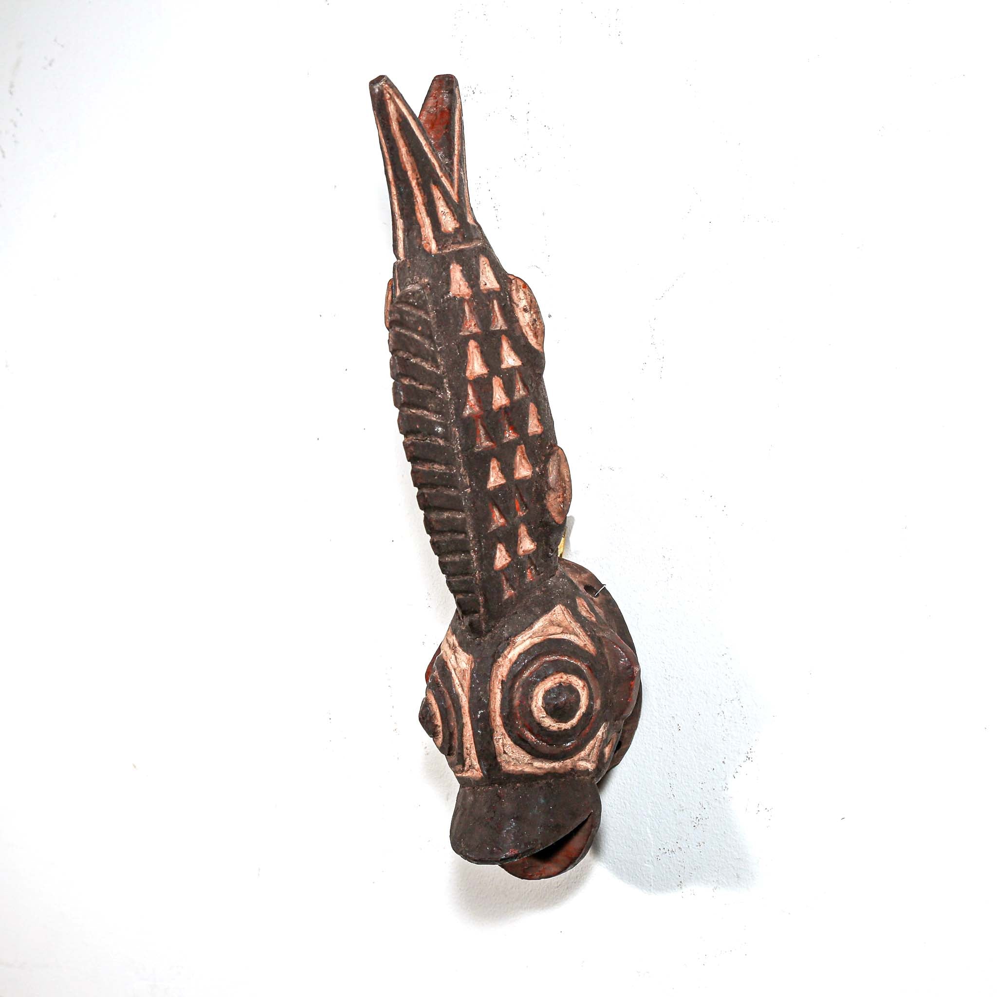 Wooden fish carving from Africa with intricate tribal patterns on a white background
