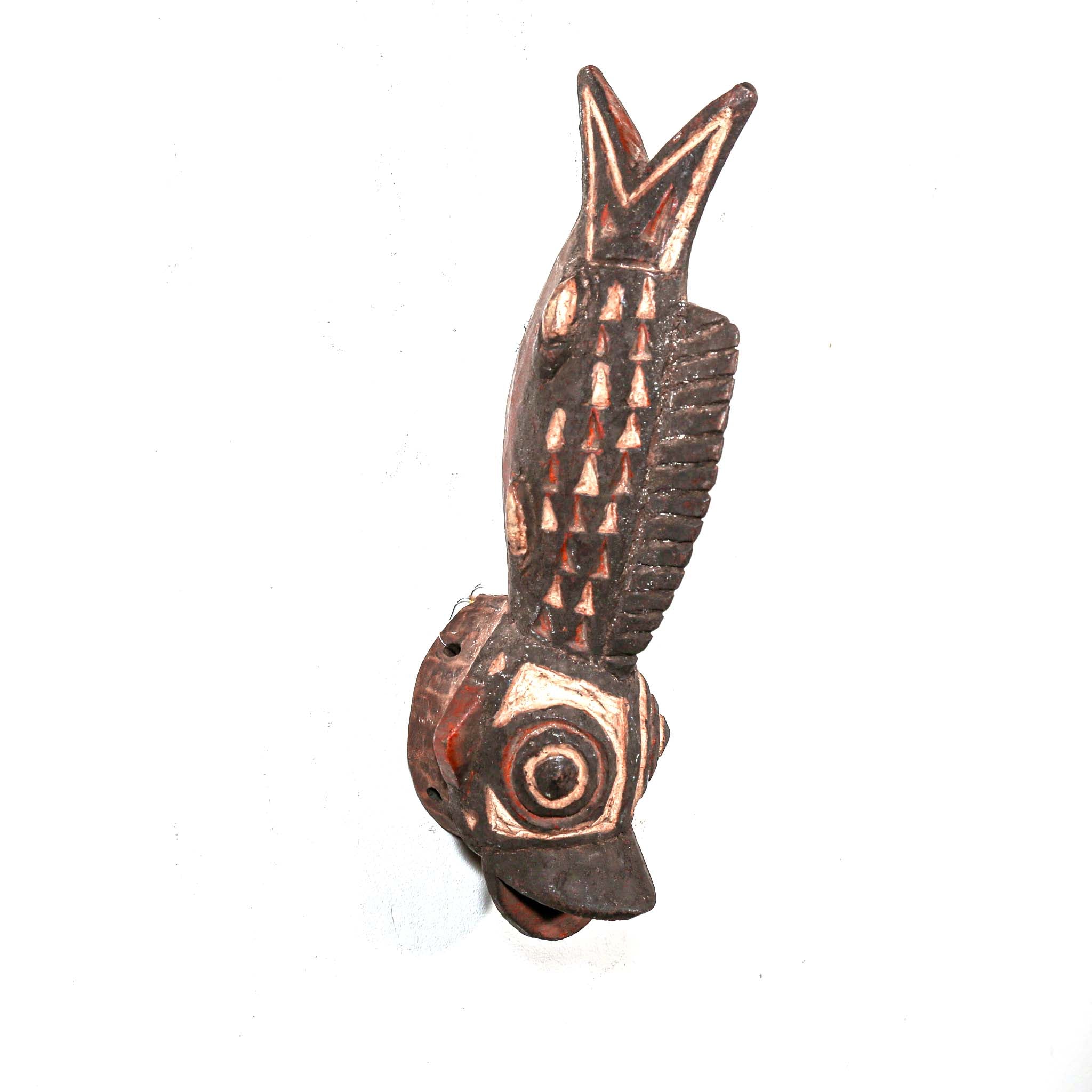 Wooden fish carving from Africa with intricate tribal patterns on a white background