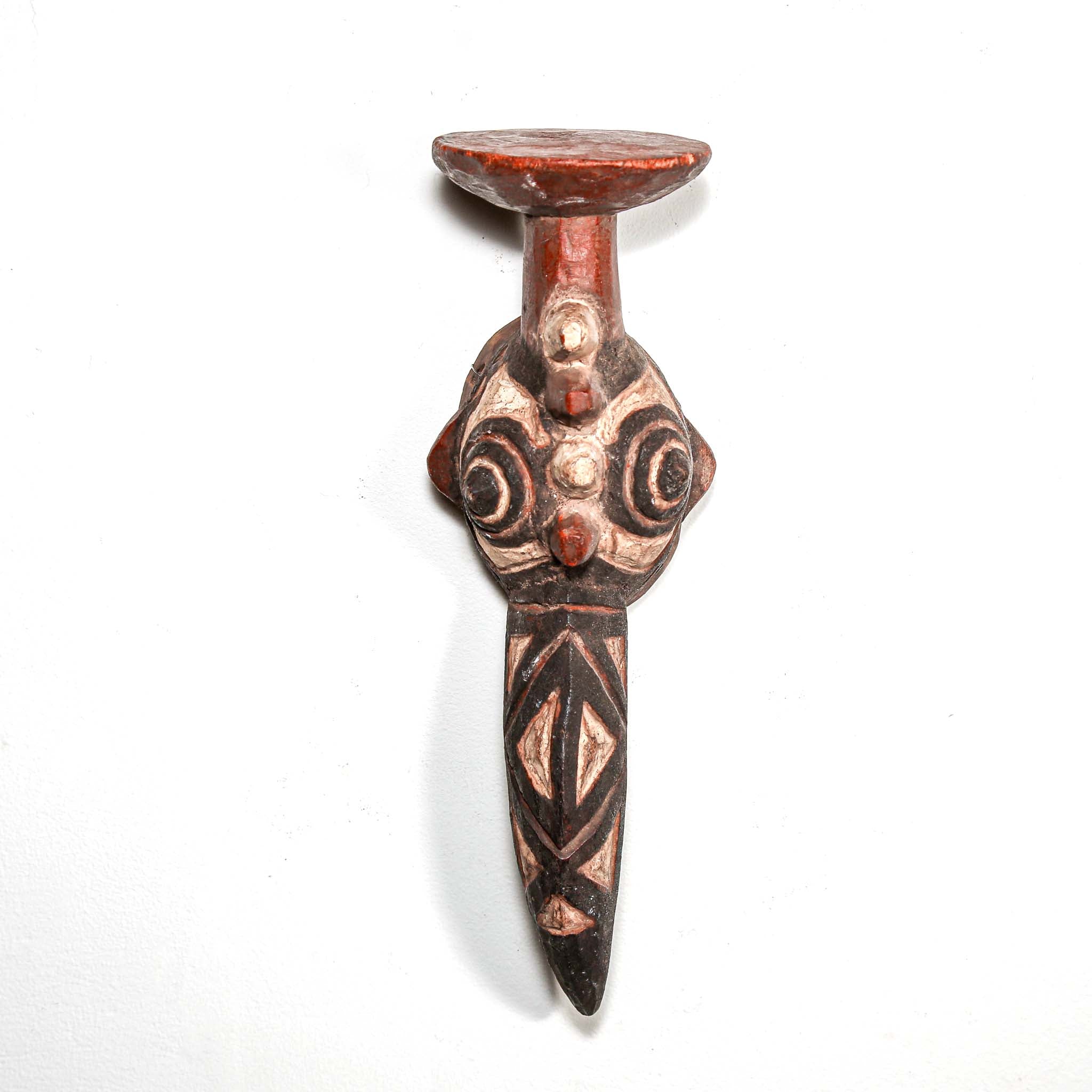 hand made carved wood bird-shaped mask with intricate designs on a white background