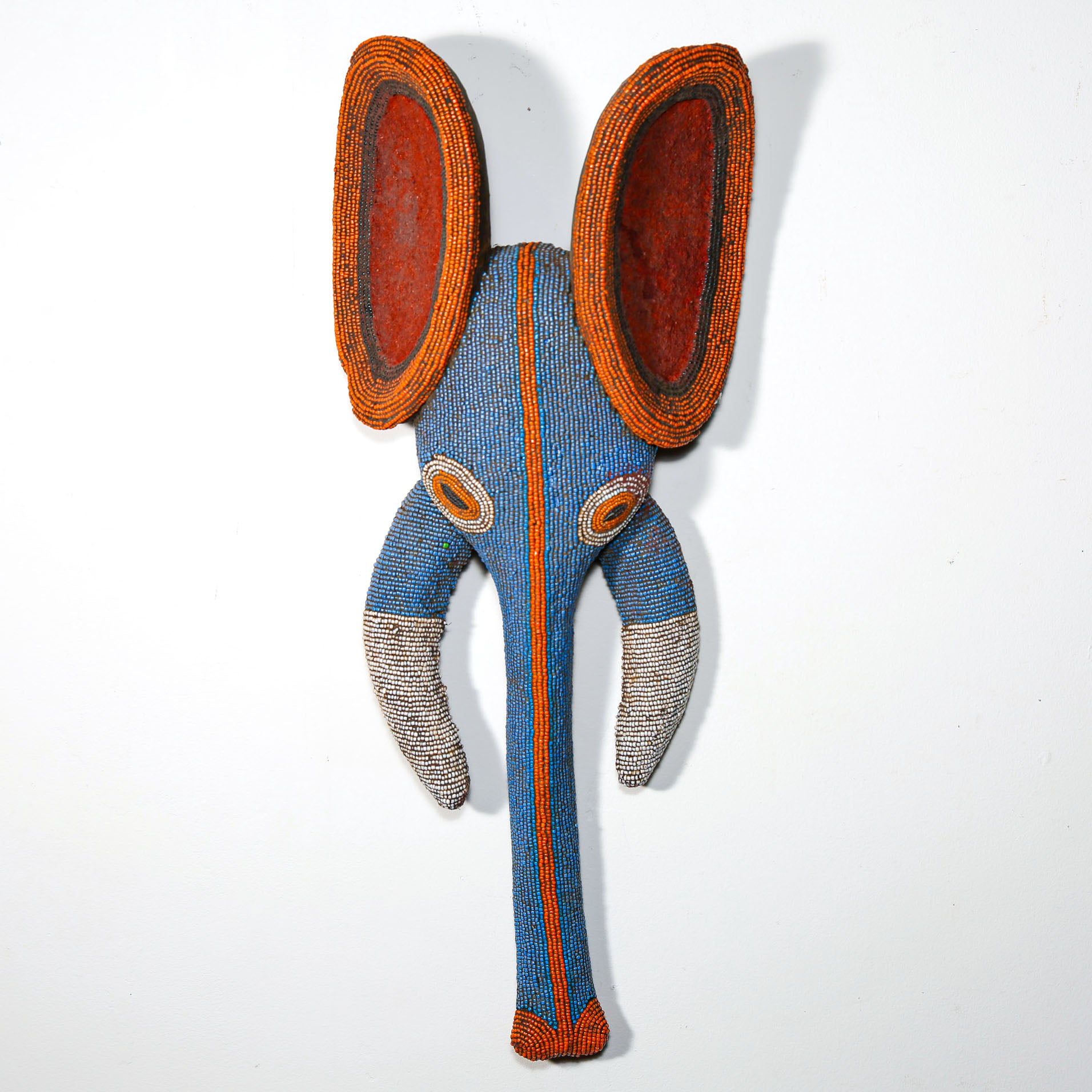 blue and orange beaded wooden elephant mask