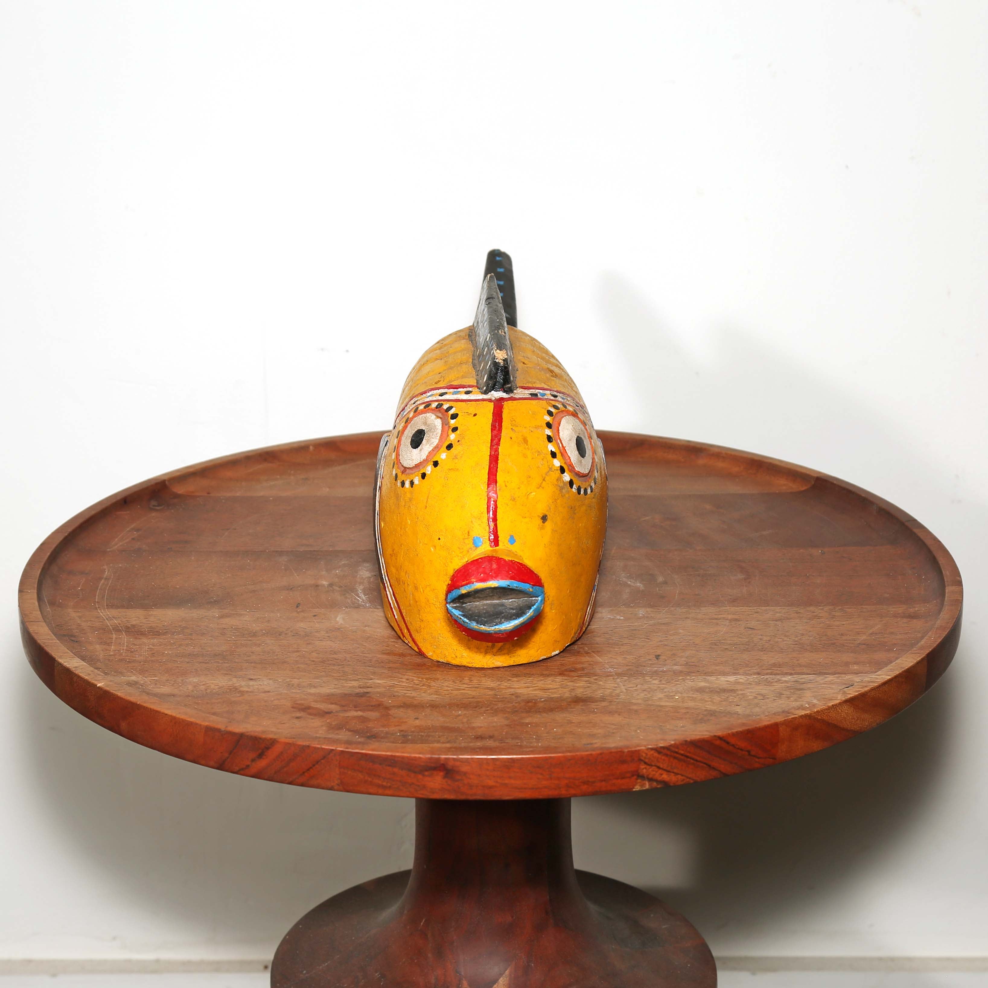 Yellow and Black Wood sculpture of a fish from Africa. Displayed on a table
