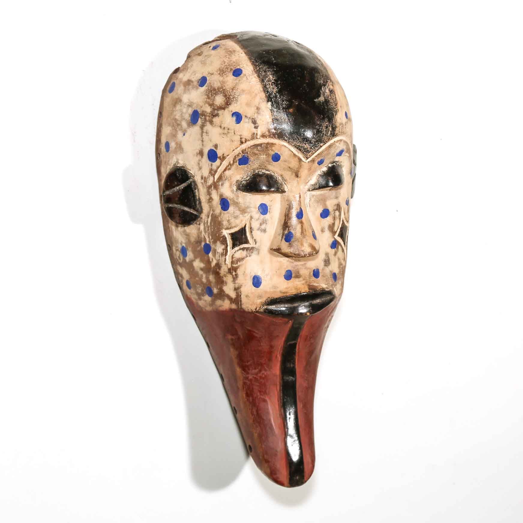 Traditional wooden mask with blue dots on a white background