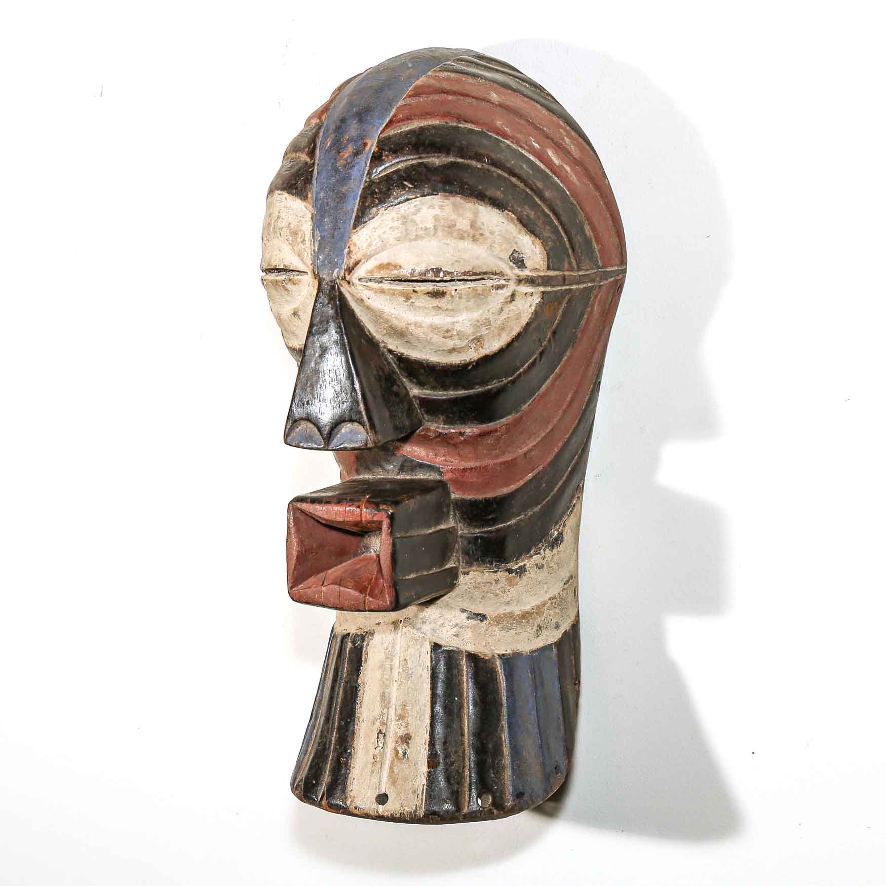 wooden mask from Africa with abstract design on a white background