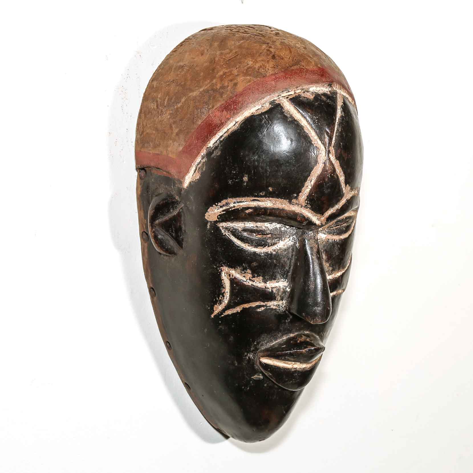 African mask with black and brown colors on a white background