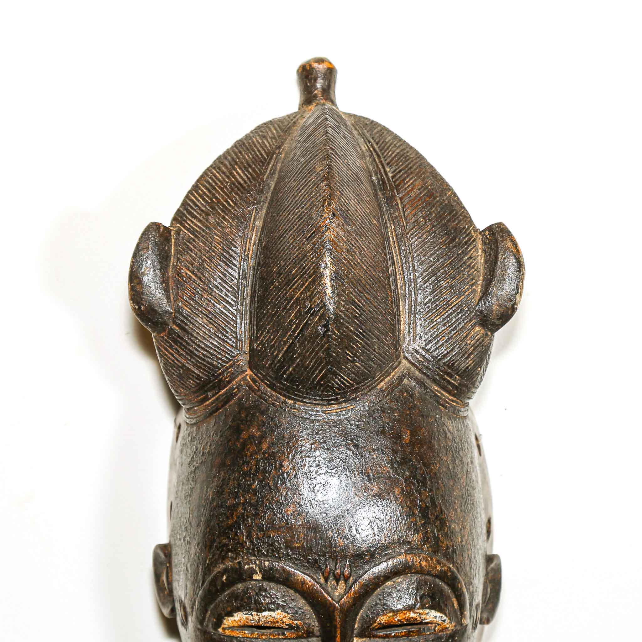 detail of the hair on a black African mask with a white background