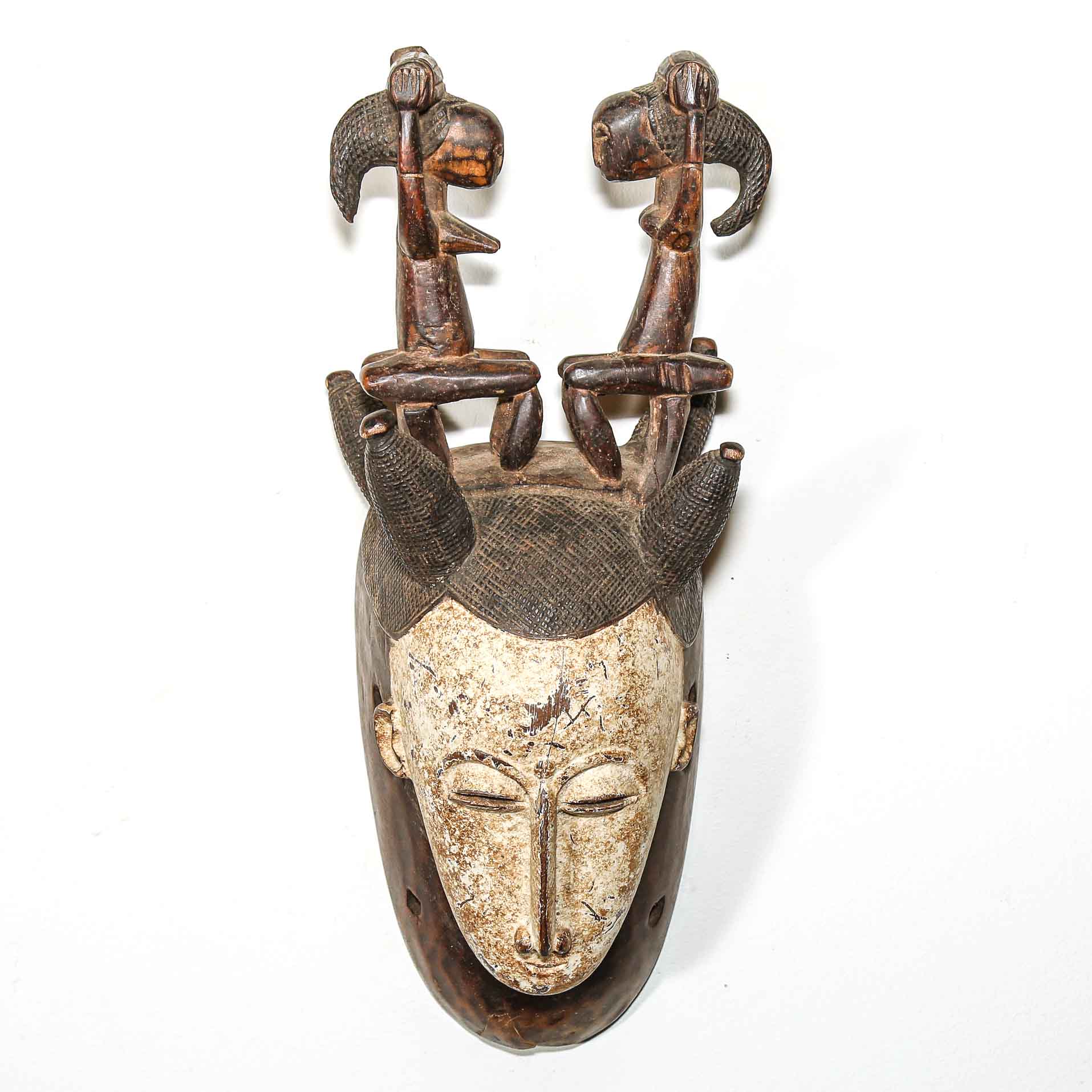 Wooden mask with intricate carvings on a white background