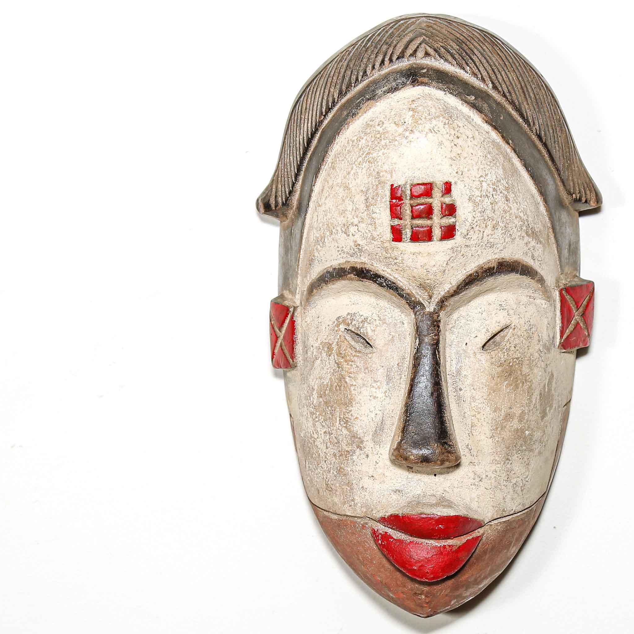 white and red painted wood mask with red accents on a white background