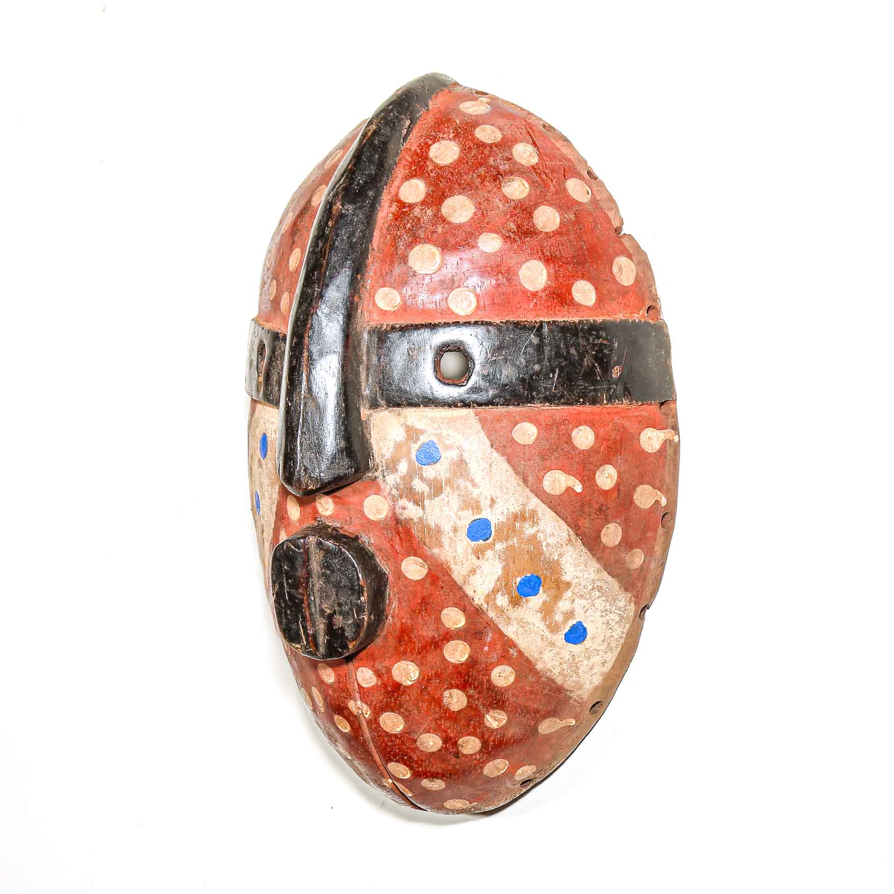 Decorative African wood mask with red, black, and white patterns on a white background