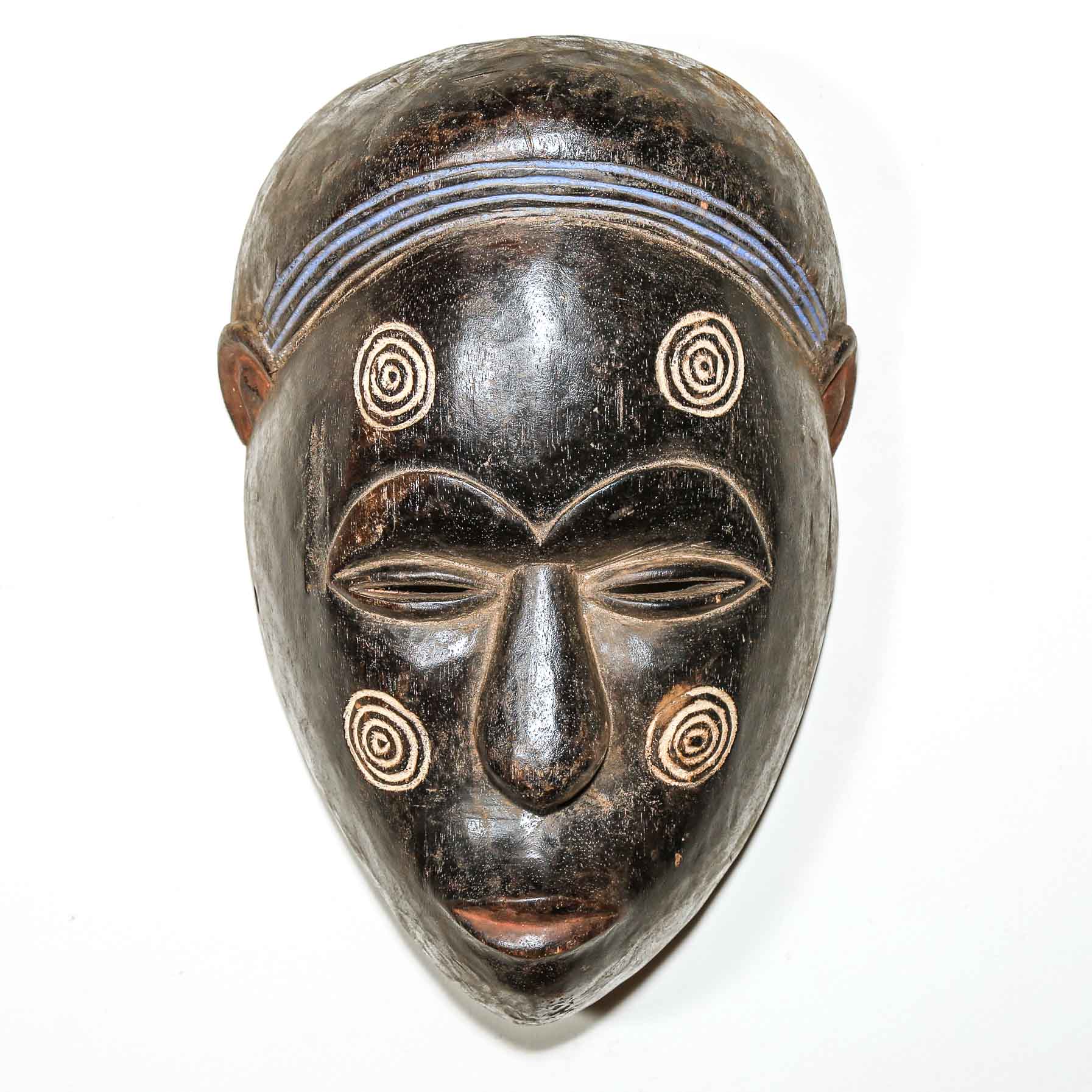 triable African wooden mask with facial features and a white background