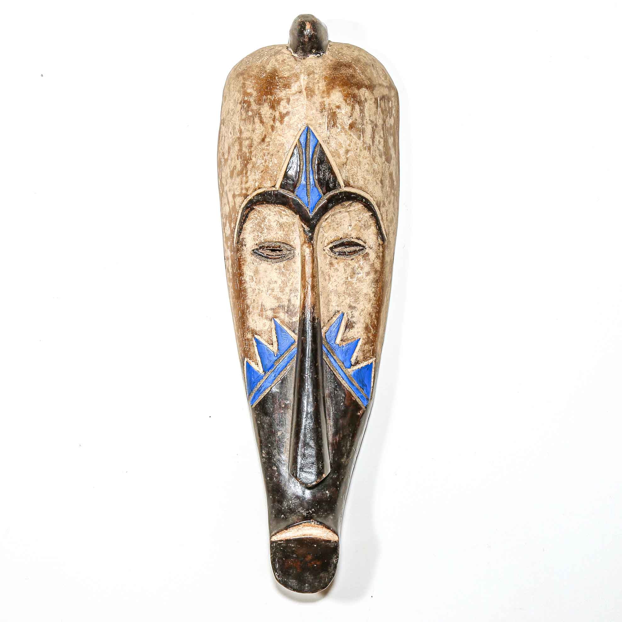 elongated wooden African mask with blue accents on a white background